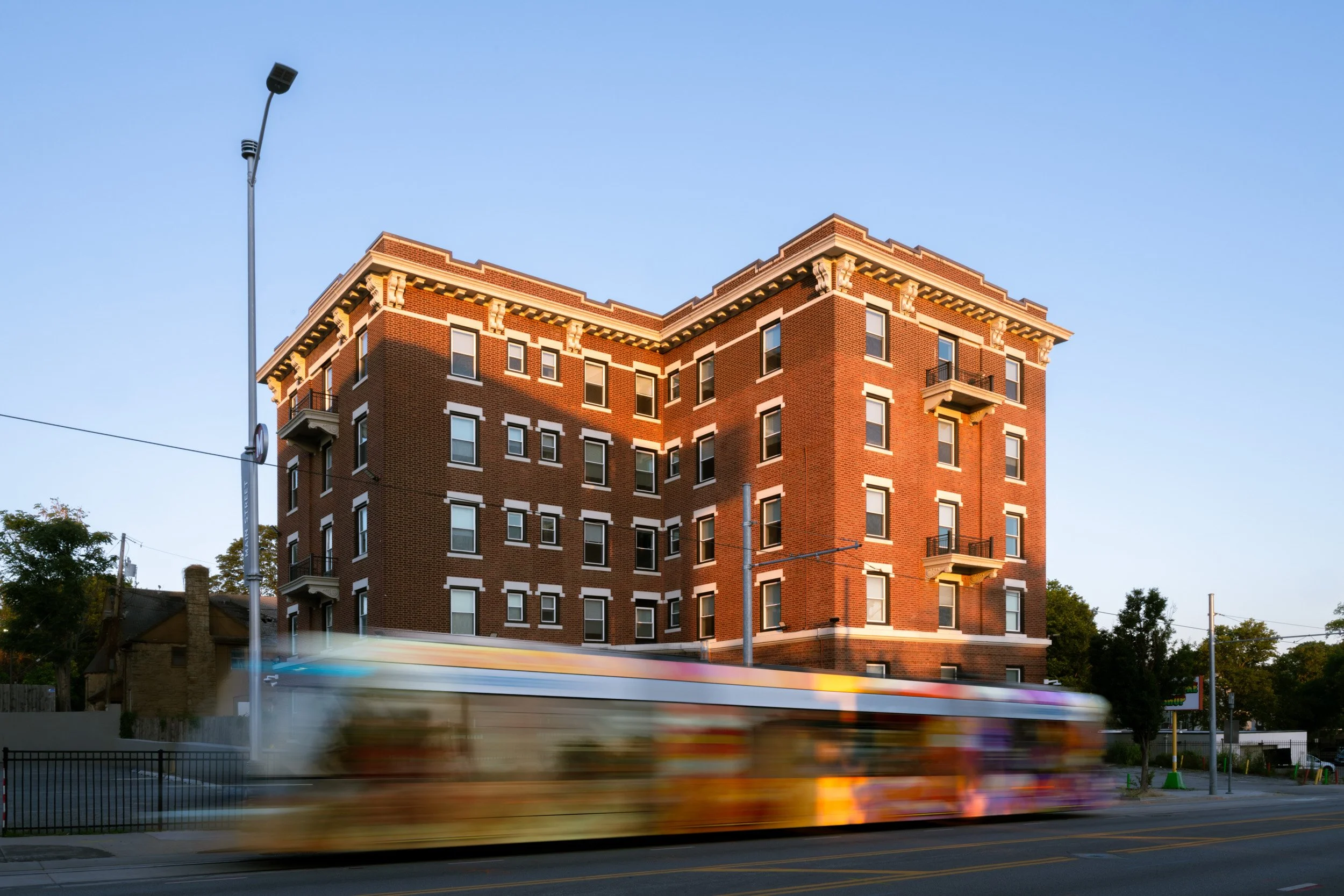 reStart's brick Family Lodge building at dusk, a Kansas City streetcar blurring past out front
