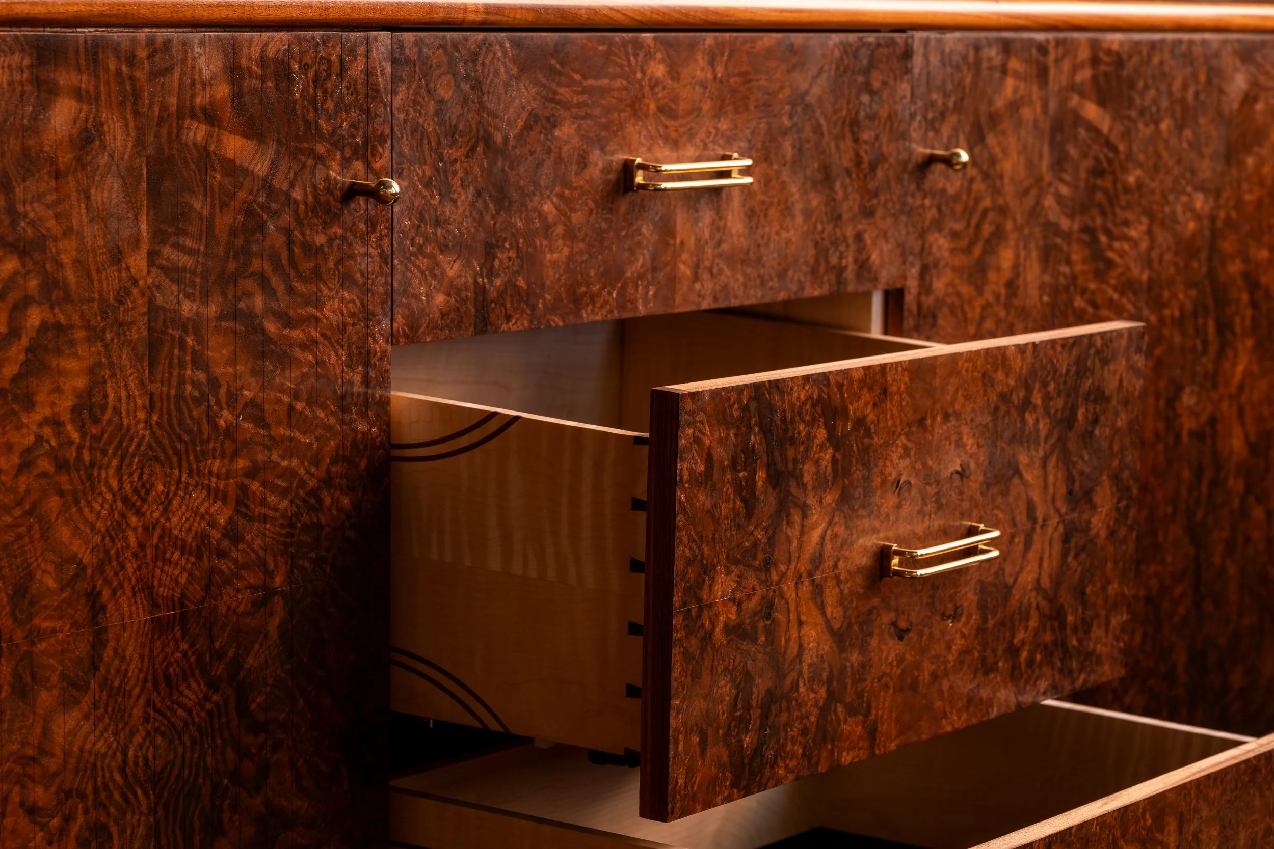 Walnut burl credenza with drawers extended to showcase interior craftsmanship.