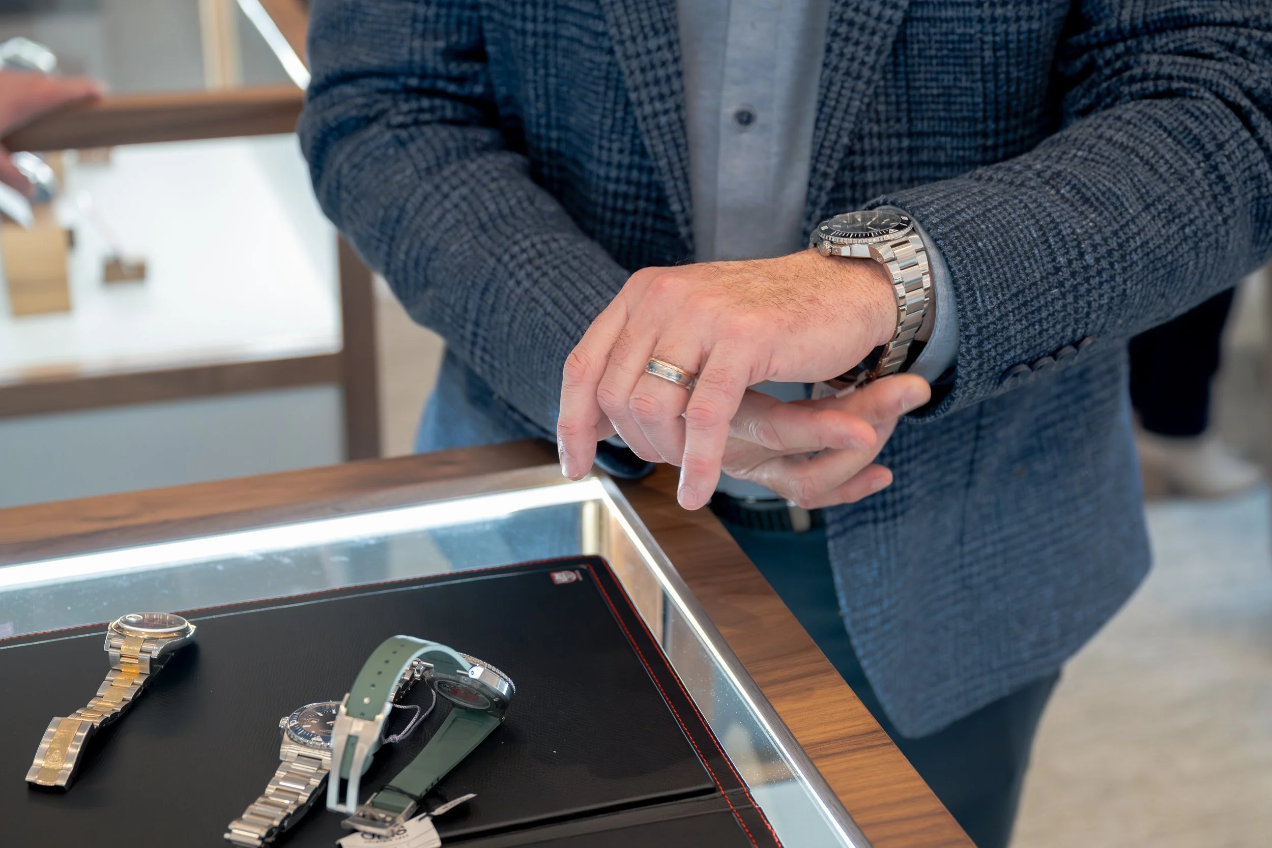 Customer examining luxury watches inside the Karats Jewelers showroom.