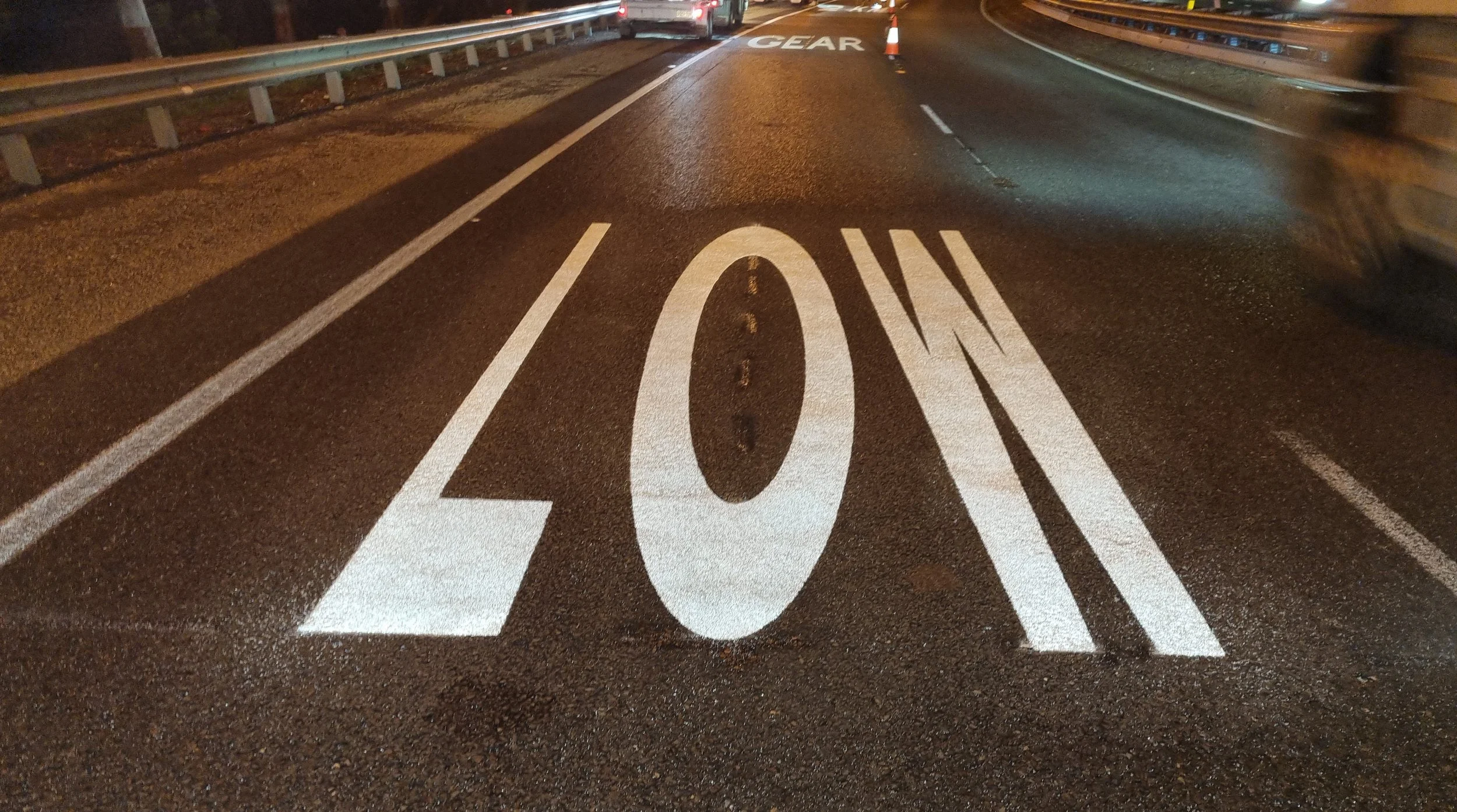 A night-time shot of a road marked with a large white word reading LOW