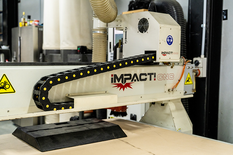 A machine labeled 'Impact CNC' in a workshop or manufacturing environment.