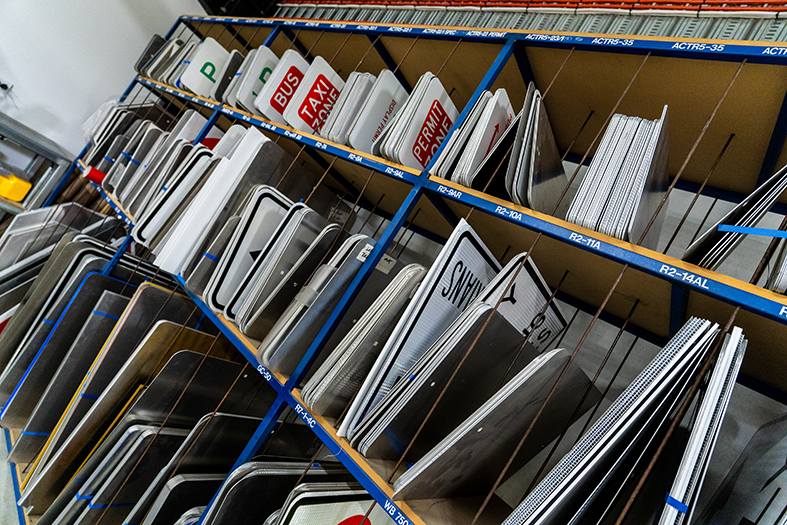 Shelves filled with various types of signage in a storage facility.