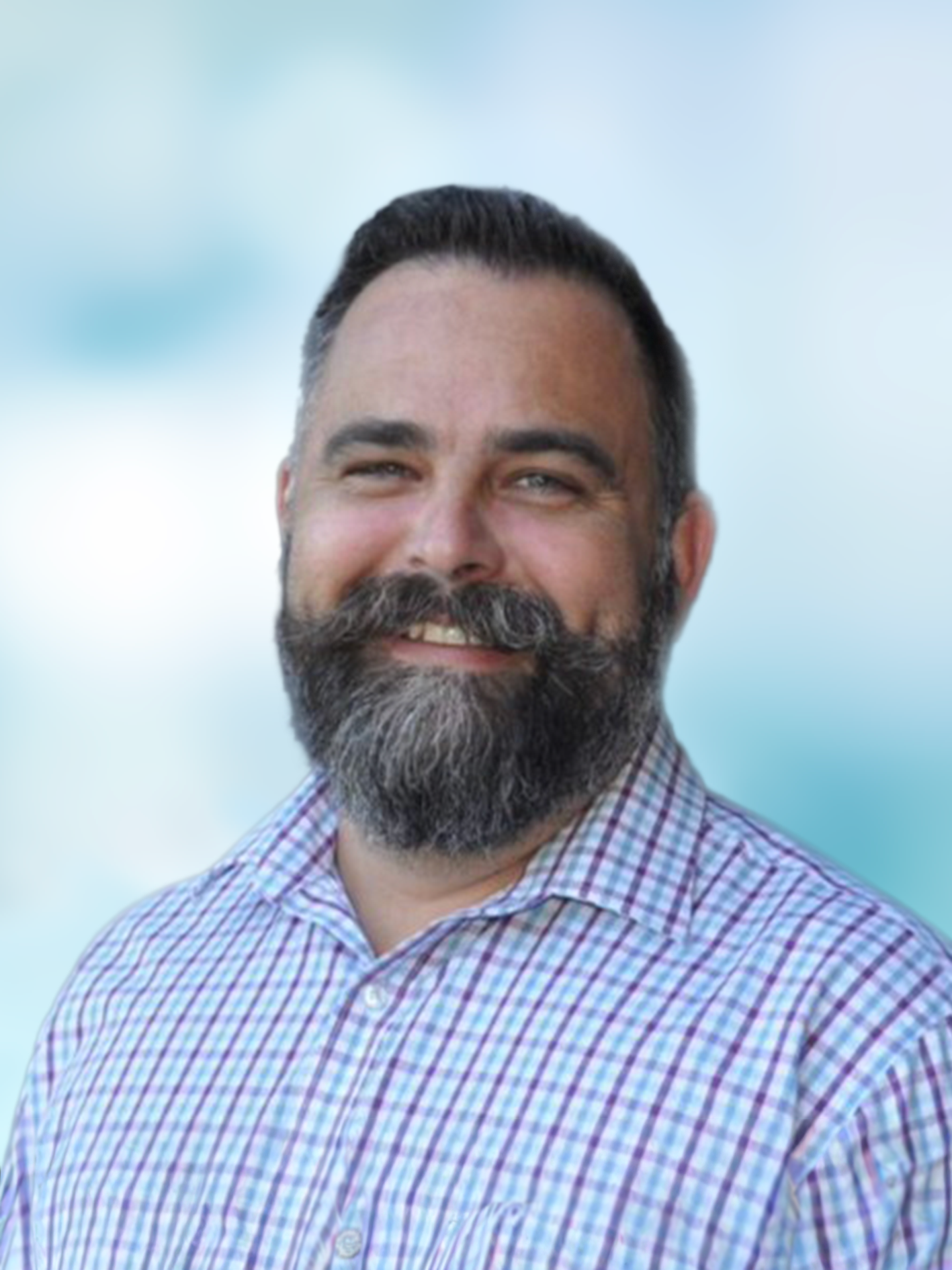 A smiling man with a full beard in a checked shirt