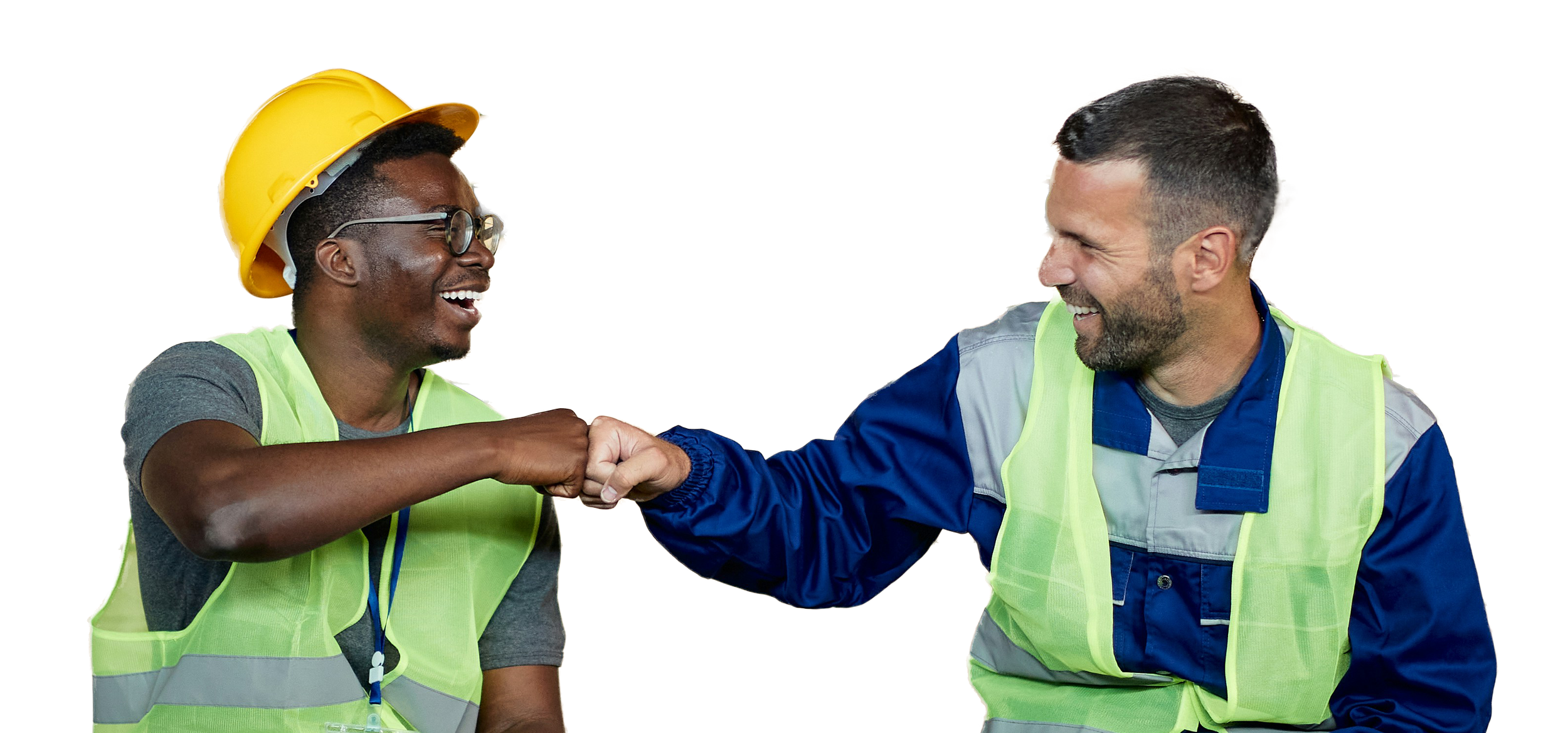 Two construction workers wearing safety vests fist-bumping and smiling at a construction site