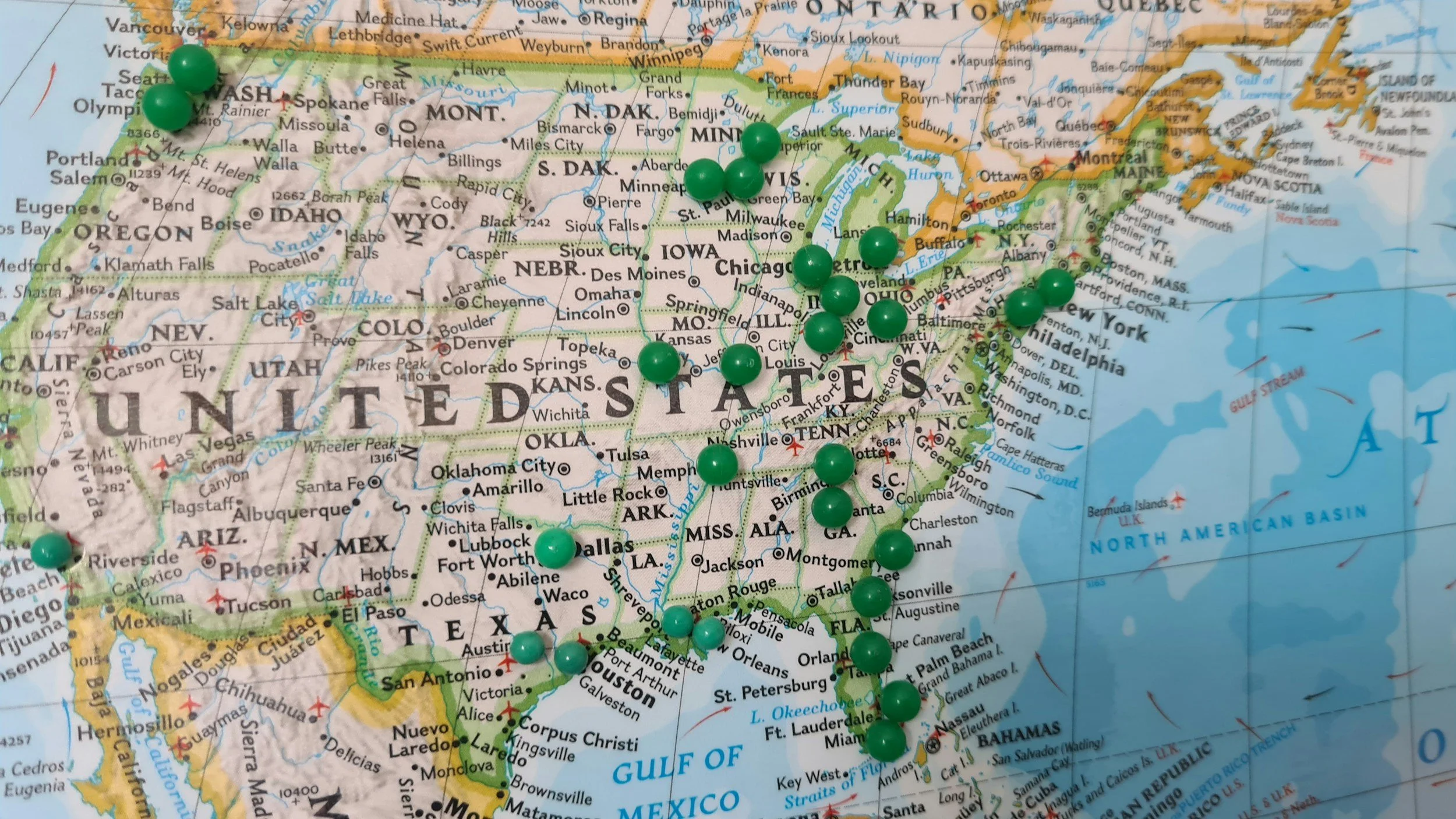 Map of the United States with green pushpins marking specific locations across the country.