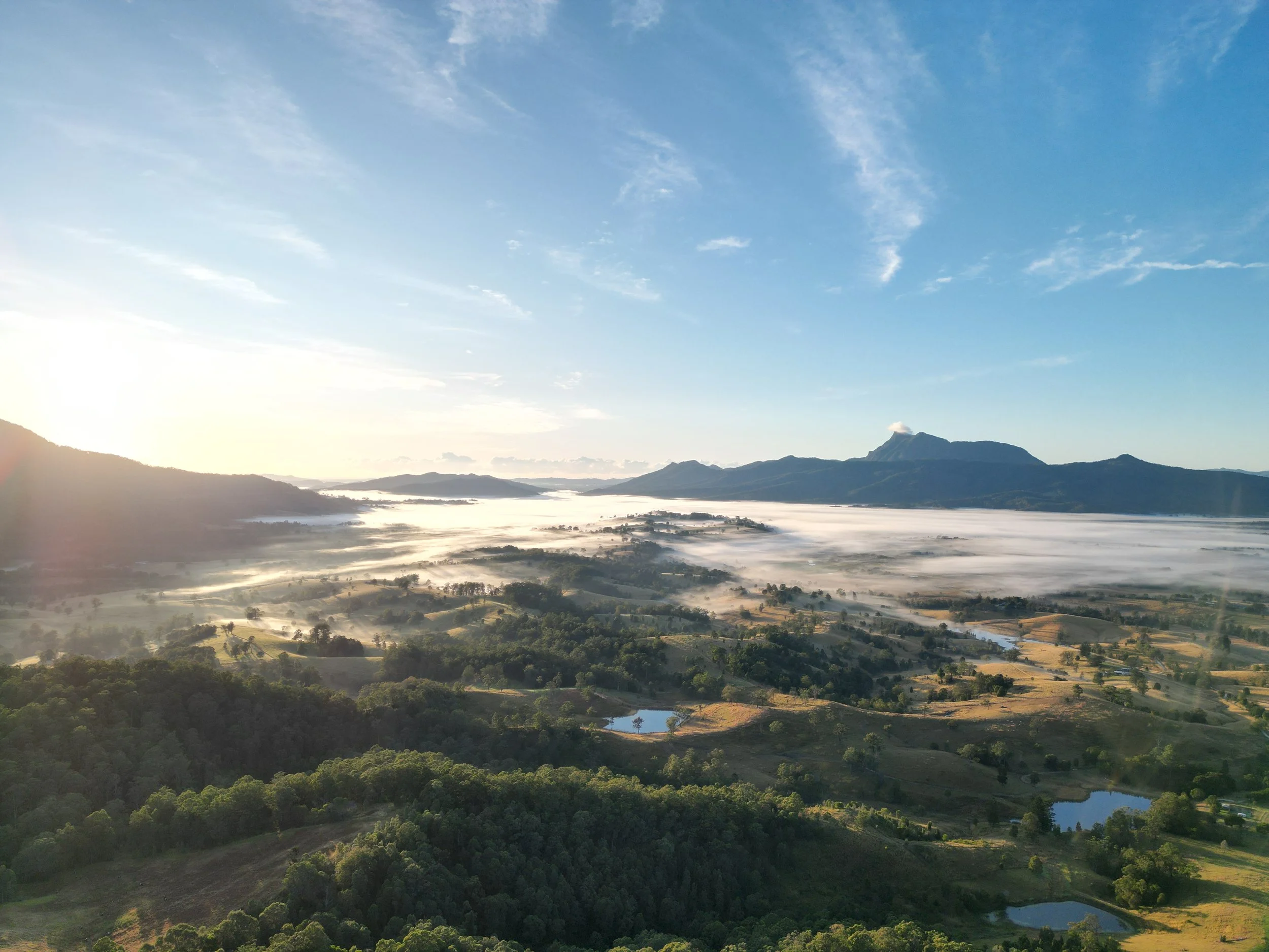 Morning light over a mountain landscape with mist filling the valley.
