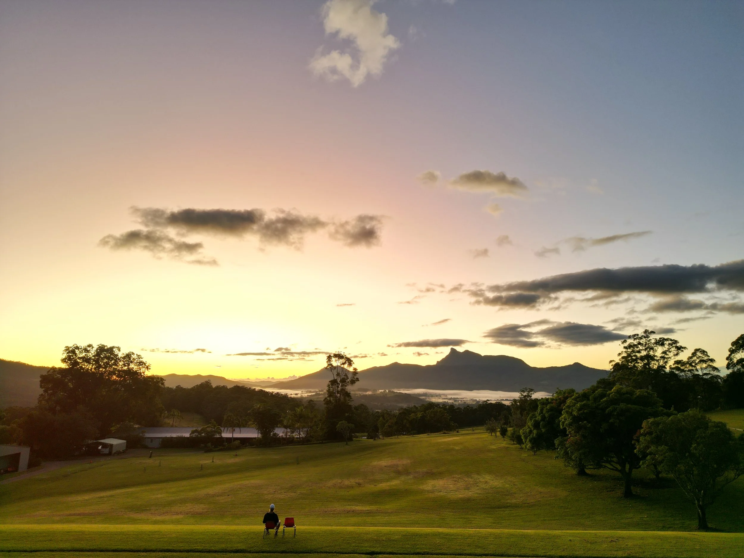 Thomas watching sunrise over the mountains with an empty chair beside him.