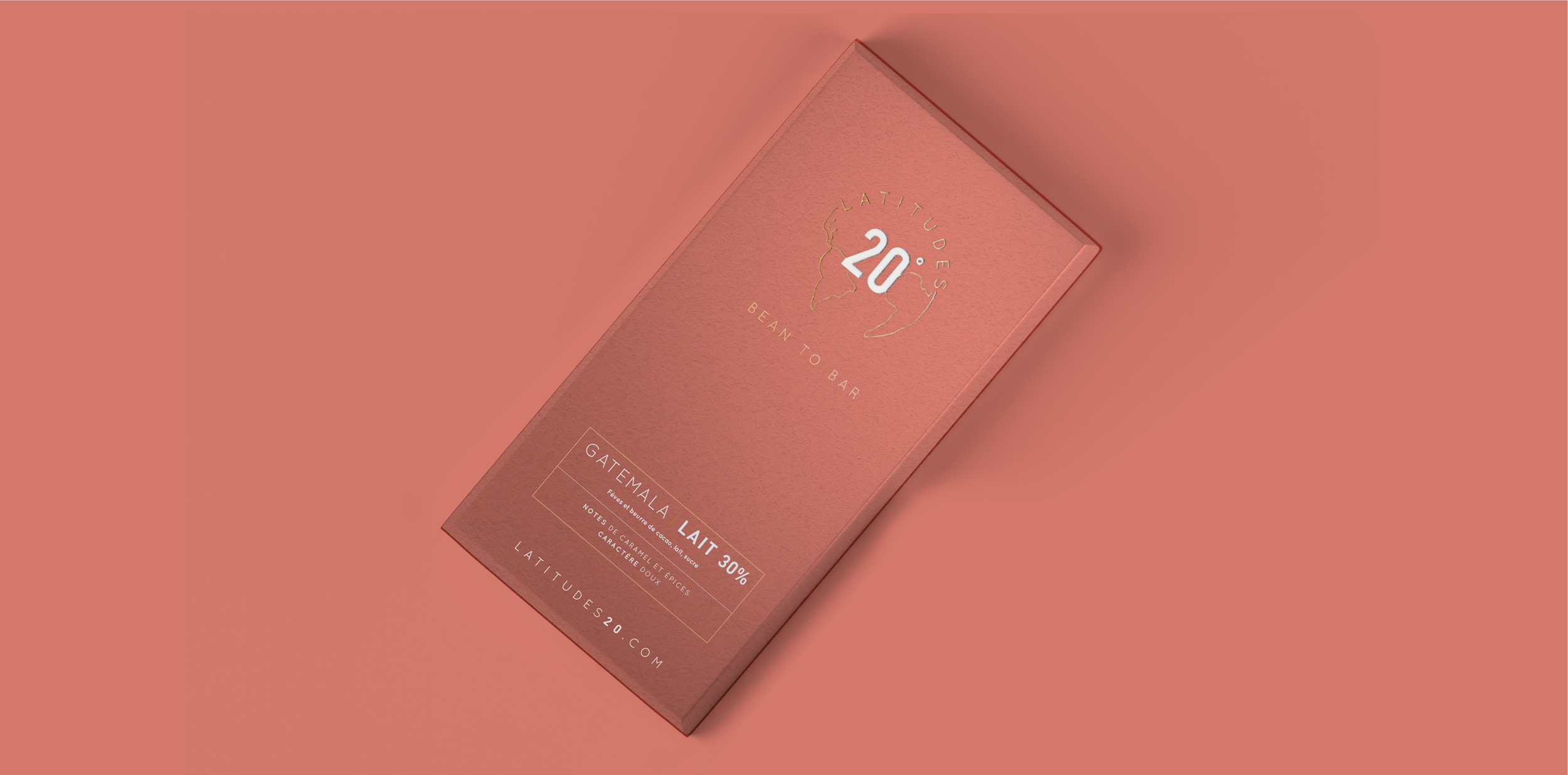 A pink chocolate bar wrapper featuring the brand 'Latitude 20' with the text 'Bean to Bar' and a map outline of South America. The flavor 'Guatemala Lait 30%' is indicated, with notes of caramel, spice, and a sweet character.