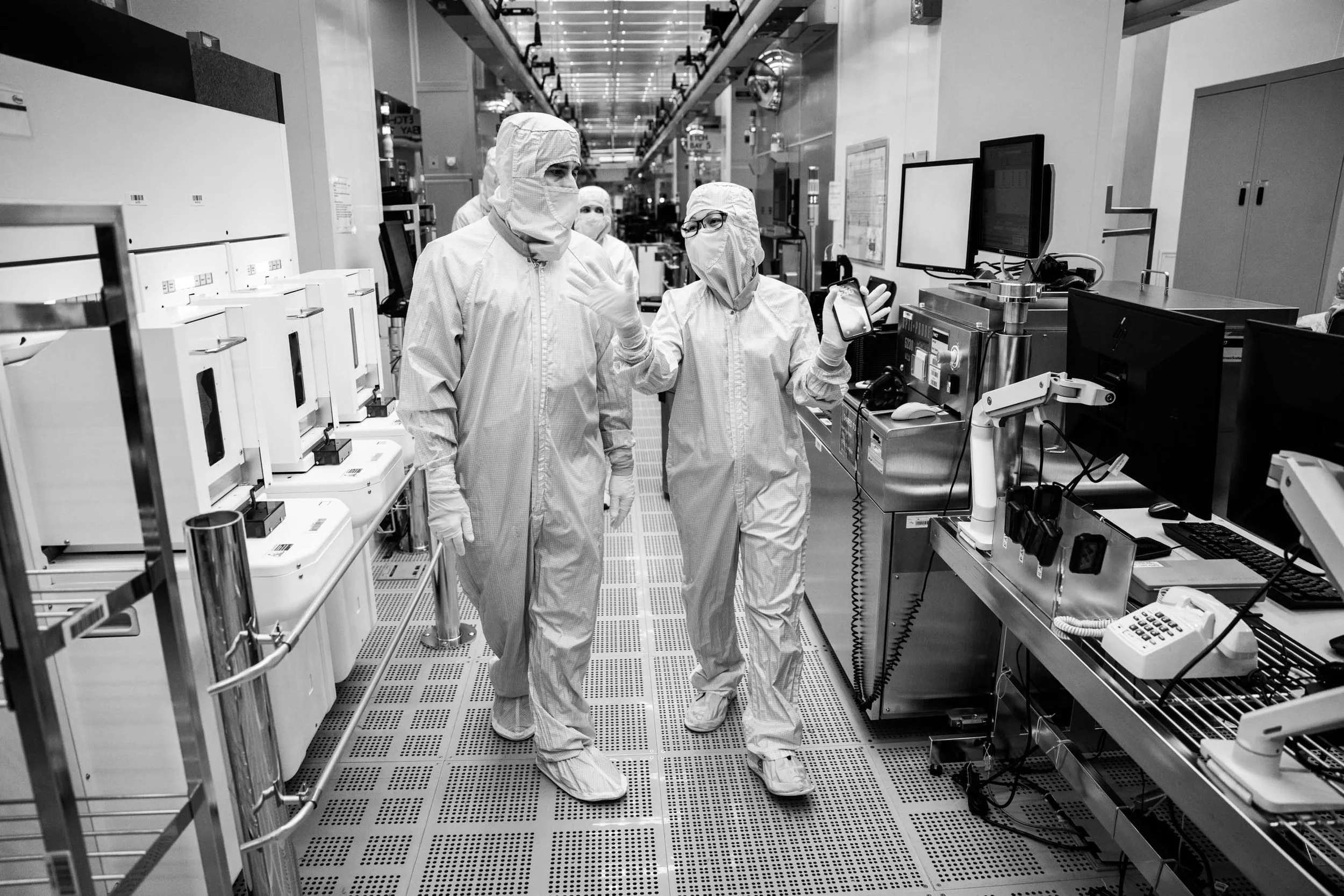 Scientists in protective suits and masks working in a laboratory with electronic equipment and computers.