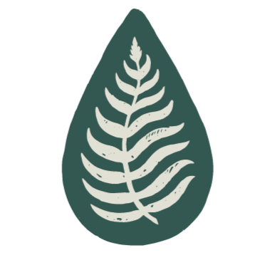 A leaf with a white fern pattern on a dark green teardrop-shaped background.