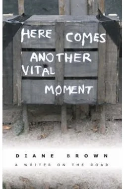 A book cover titled 'Here Comes Another Vital Moment' by Diane Brown, featuring a gray wooden fence with white painted text.