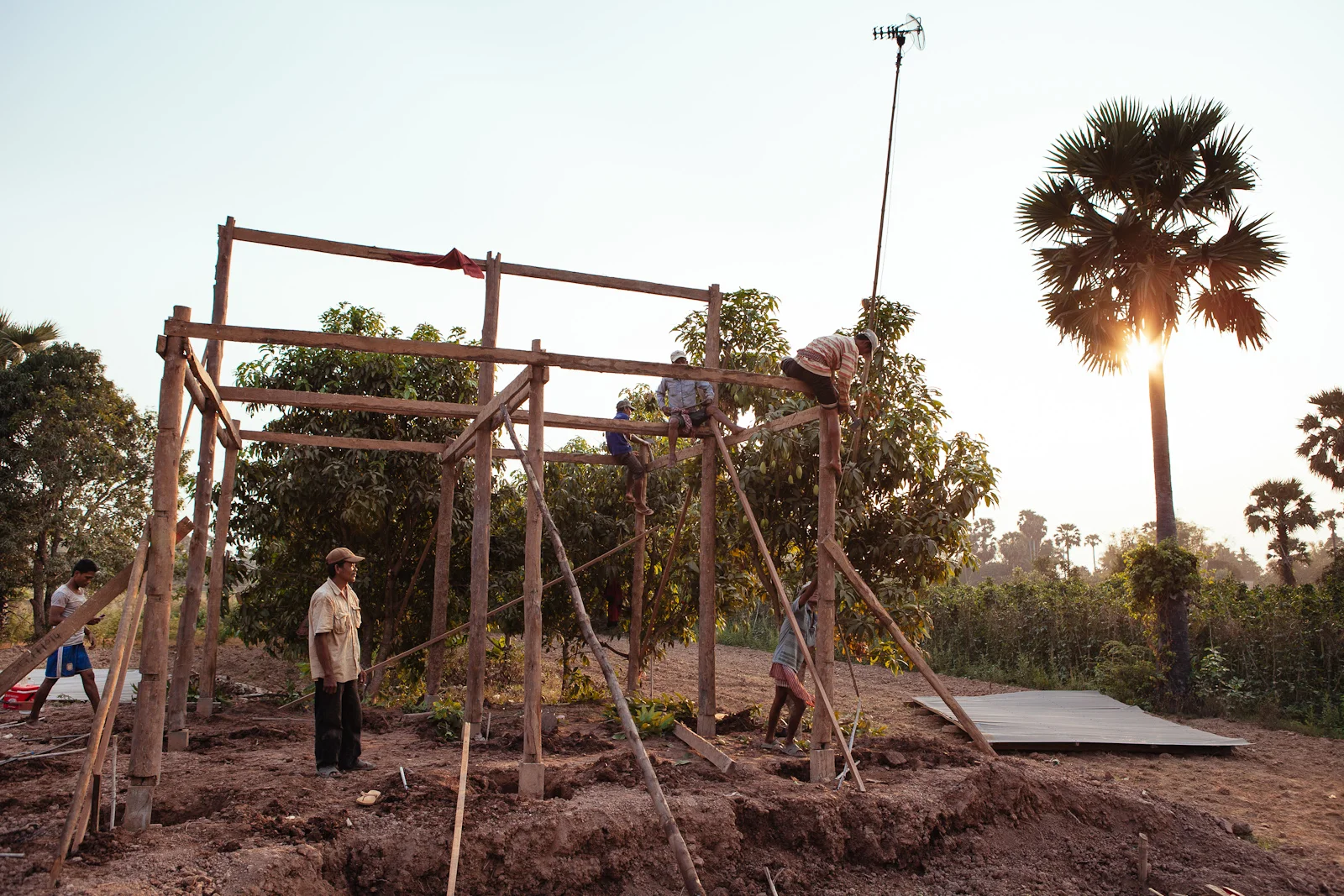 Local men in a remote village work together to build a simple house.