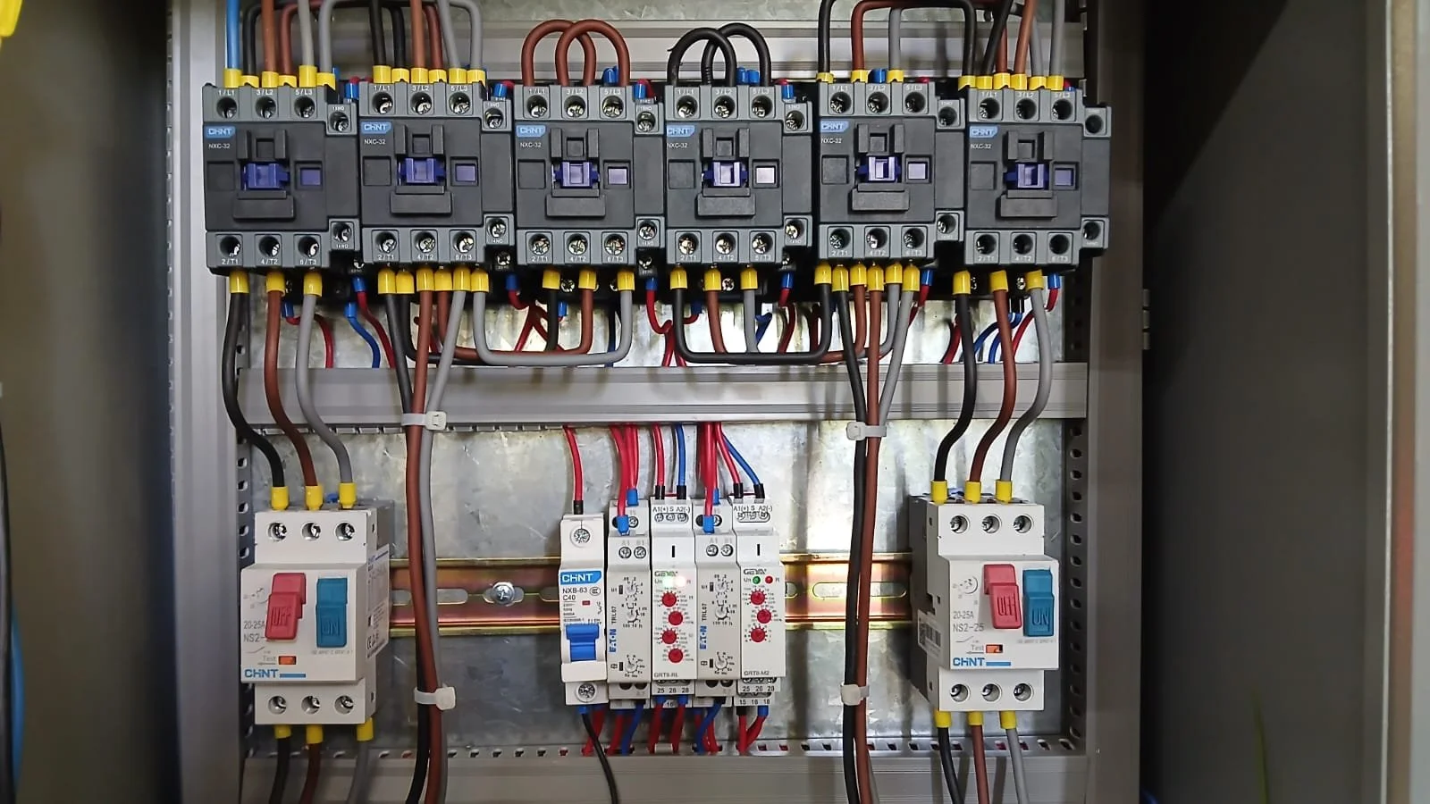 Electrical control panel with circuit breakers, relays, and wiring.