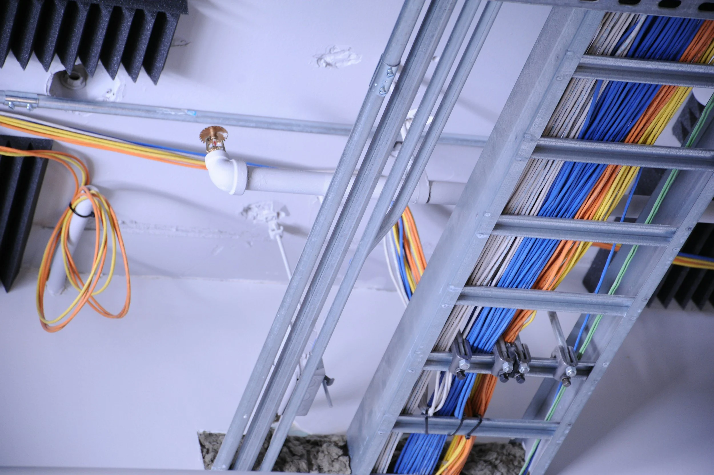 View of a ceiling with electrical wiring, metal framing, and insulation in an unfinished construction or renovation setting.