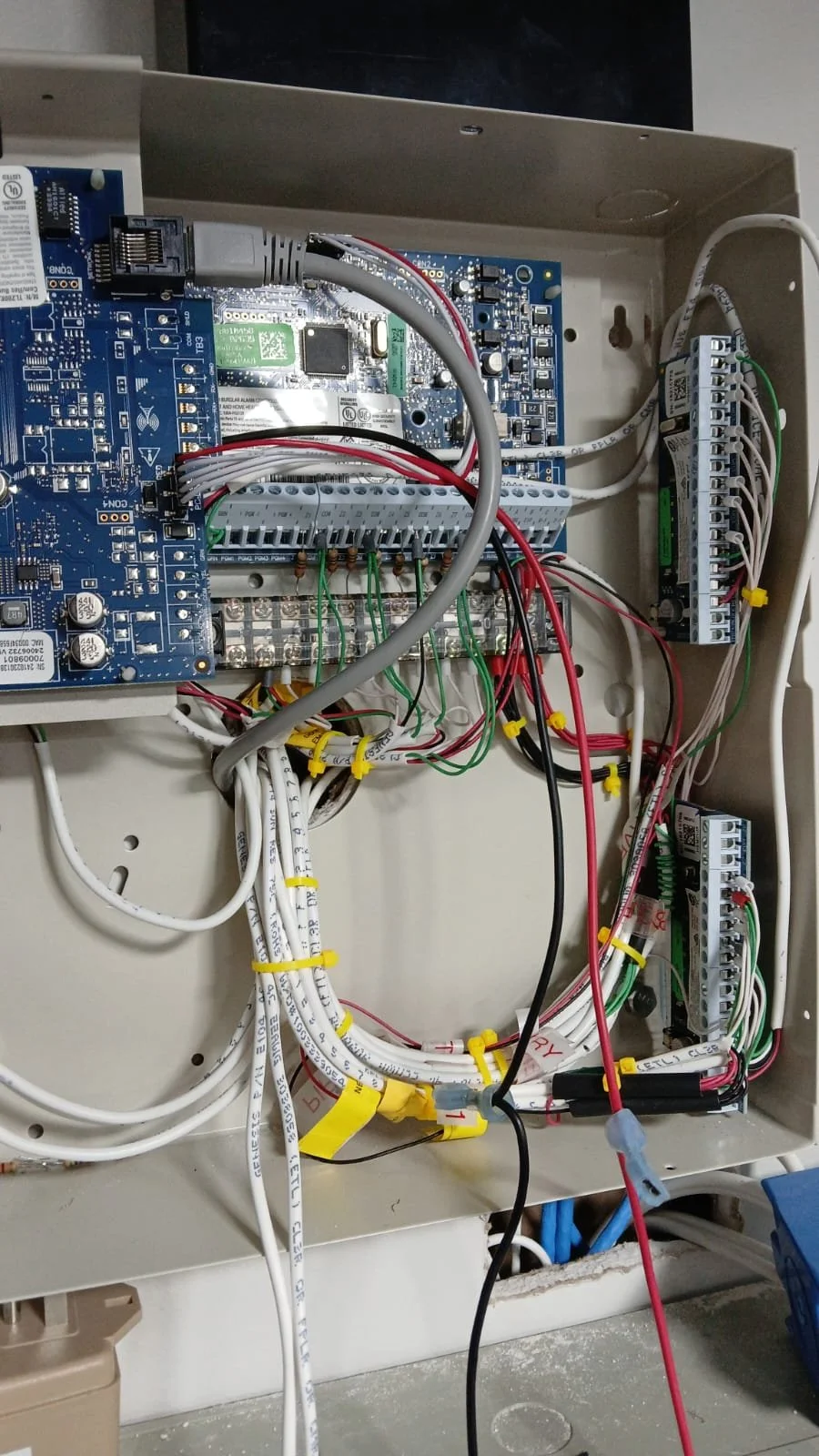 Inside an electrical control box with various wires, circuit boards, and connection terminals.