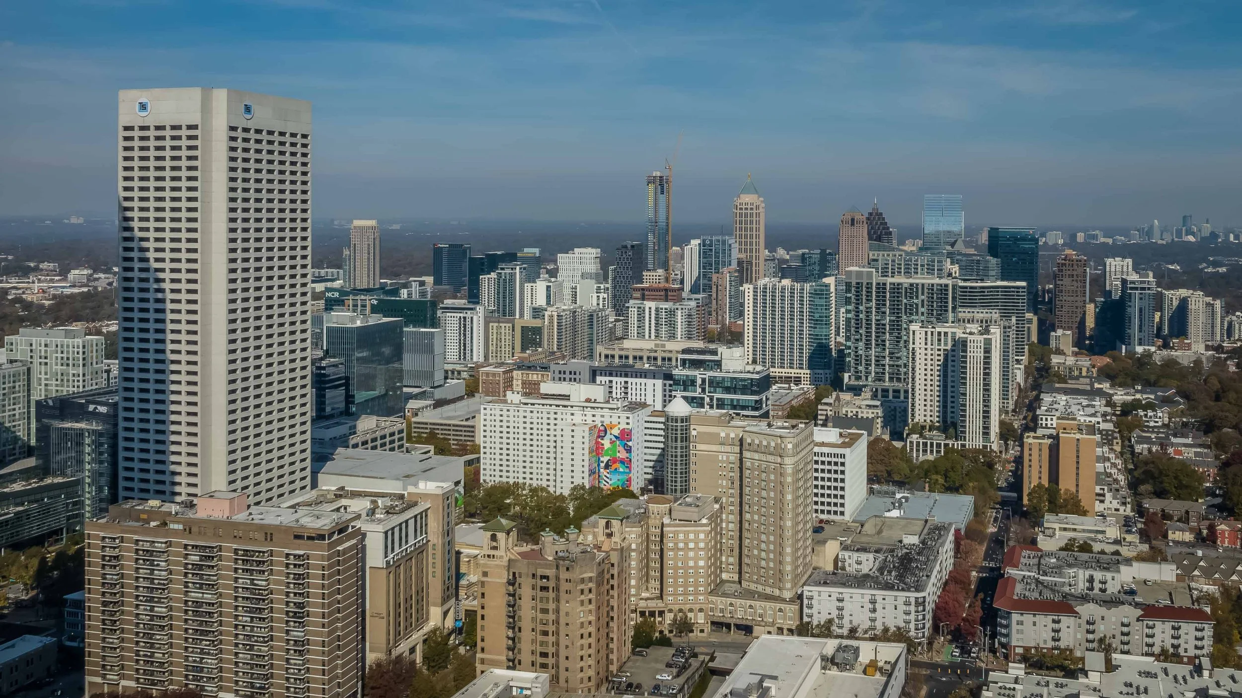 A city skyline with tall skyscrapers and buildings under a blue sky in a metropolitan area.