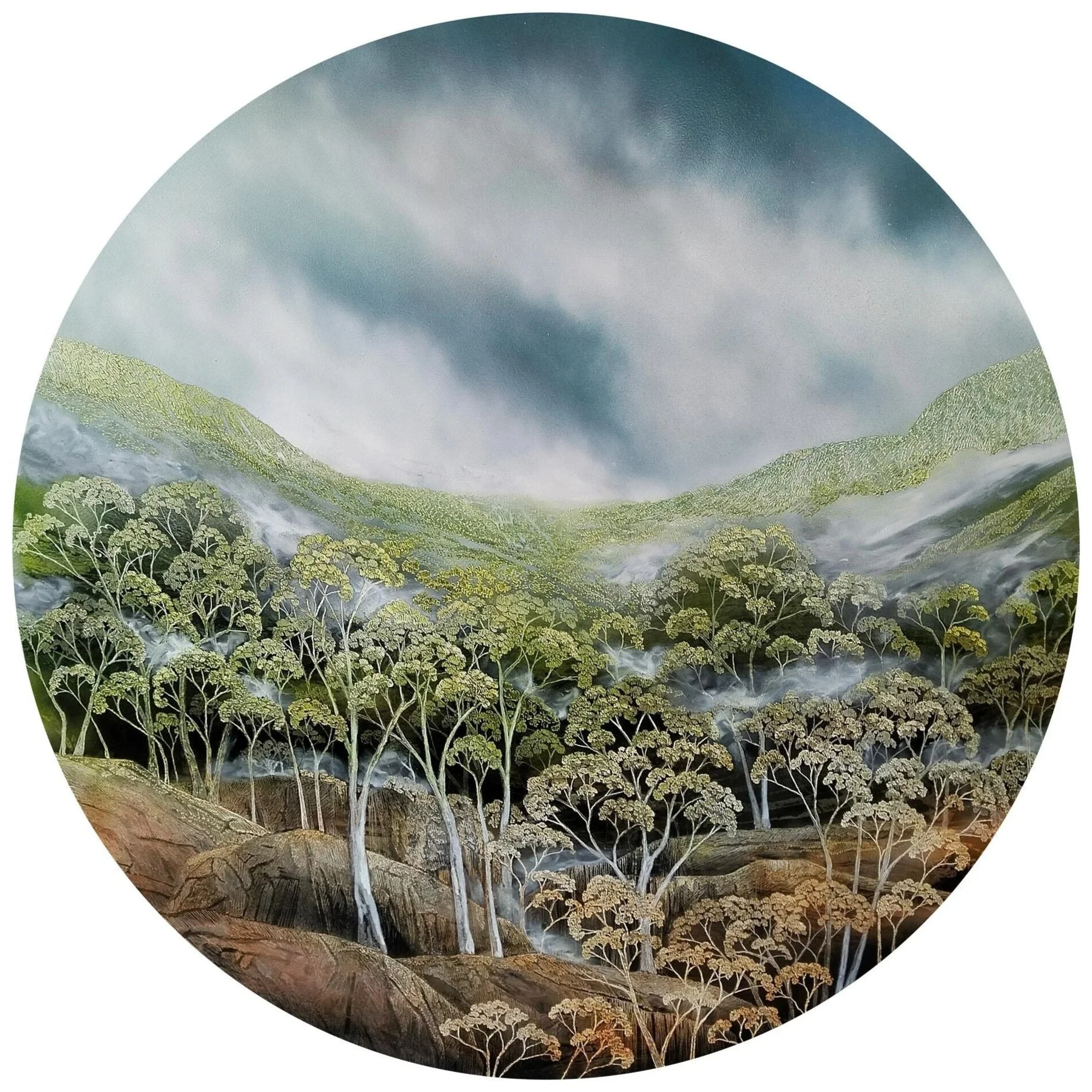 A landscape on a round board featuring trees on rolling hills under a cloudy sky, in the medium of ink, acrylic and soldering iron, by Australian artist Penelope Oates.