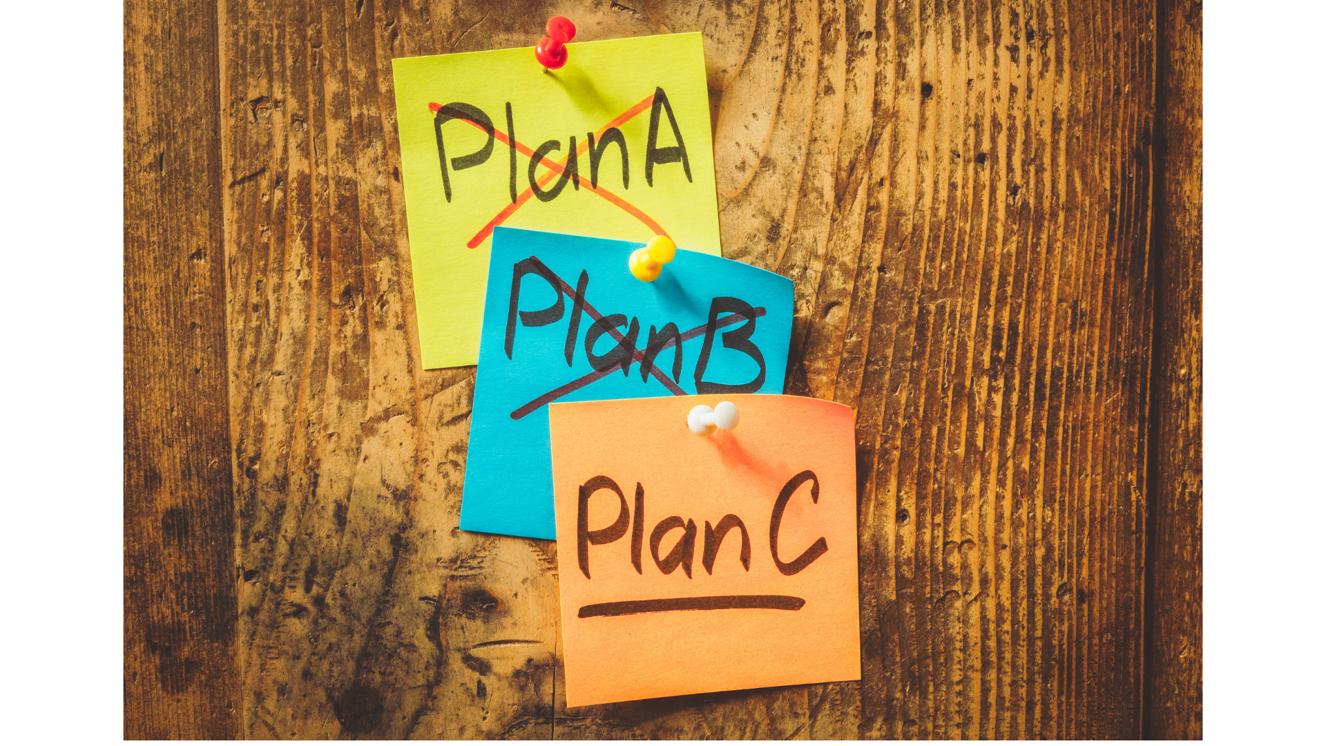 Colorful sticky notes pinned to a wooden surface. The notes have various plans written on them with some crossed out, including Plan A, Plan B, and Plan C.