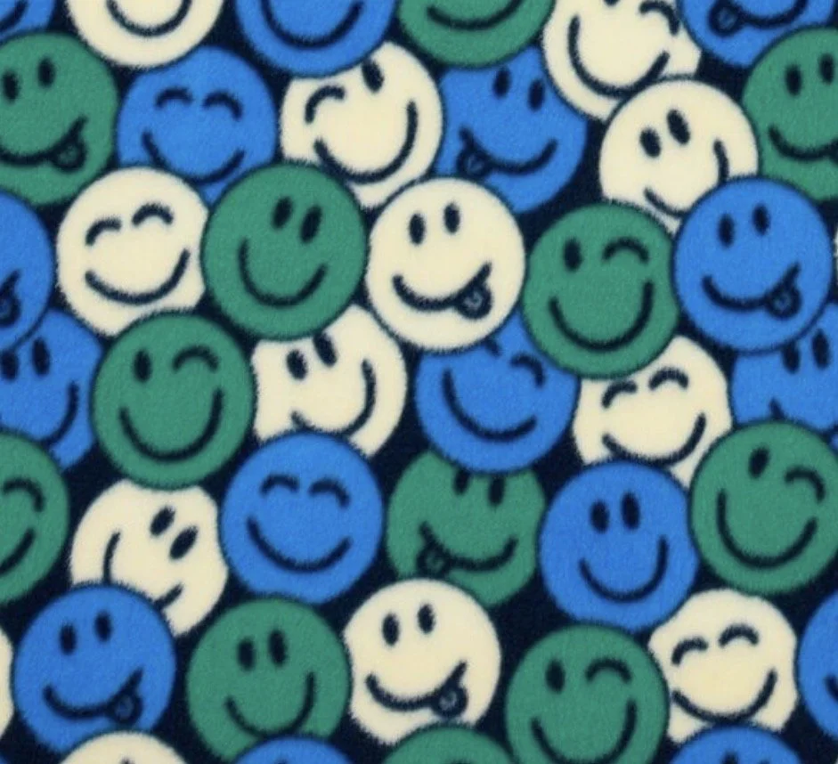 A close-up of numerous colorful smiley face stickers in white, blue, and green with various happy and playful expressions.