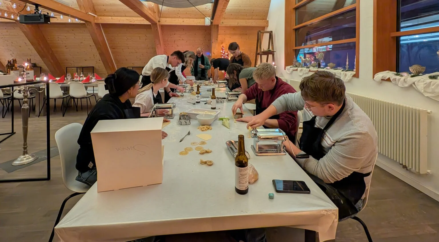 Menschen beim Keksebacken in einem festlich dekorierten Raum.