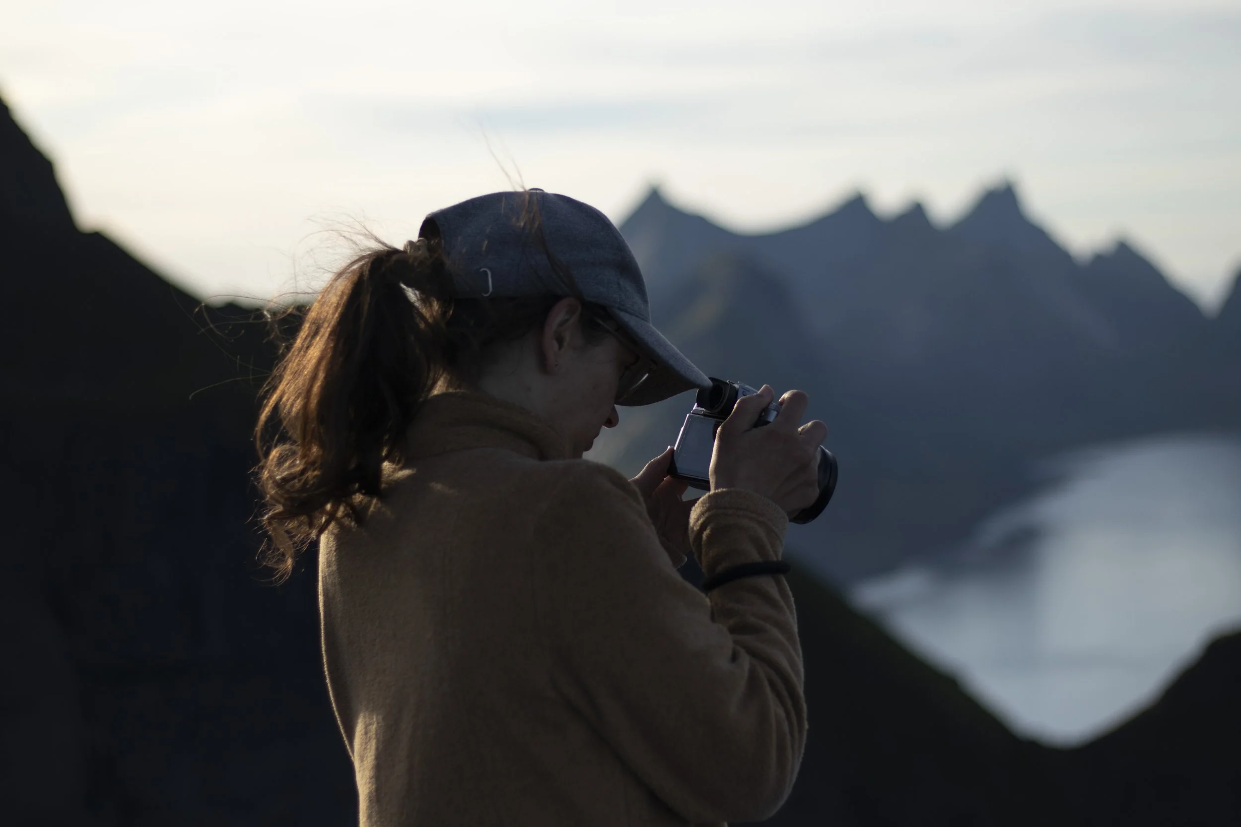 Fotografin auf den Lofoten auf dem Reinbringen mit dem Blick auf die spektakulären norwegischen Berge und Fjorde
