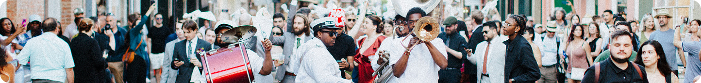 Brass band musicians and a crowd in a French Quarter street