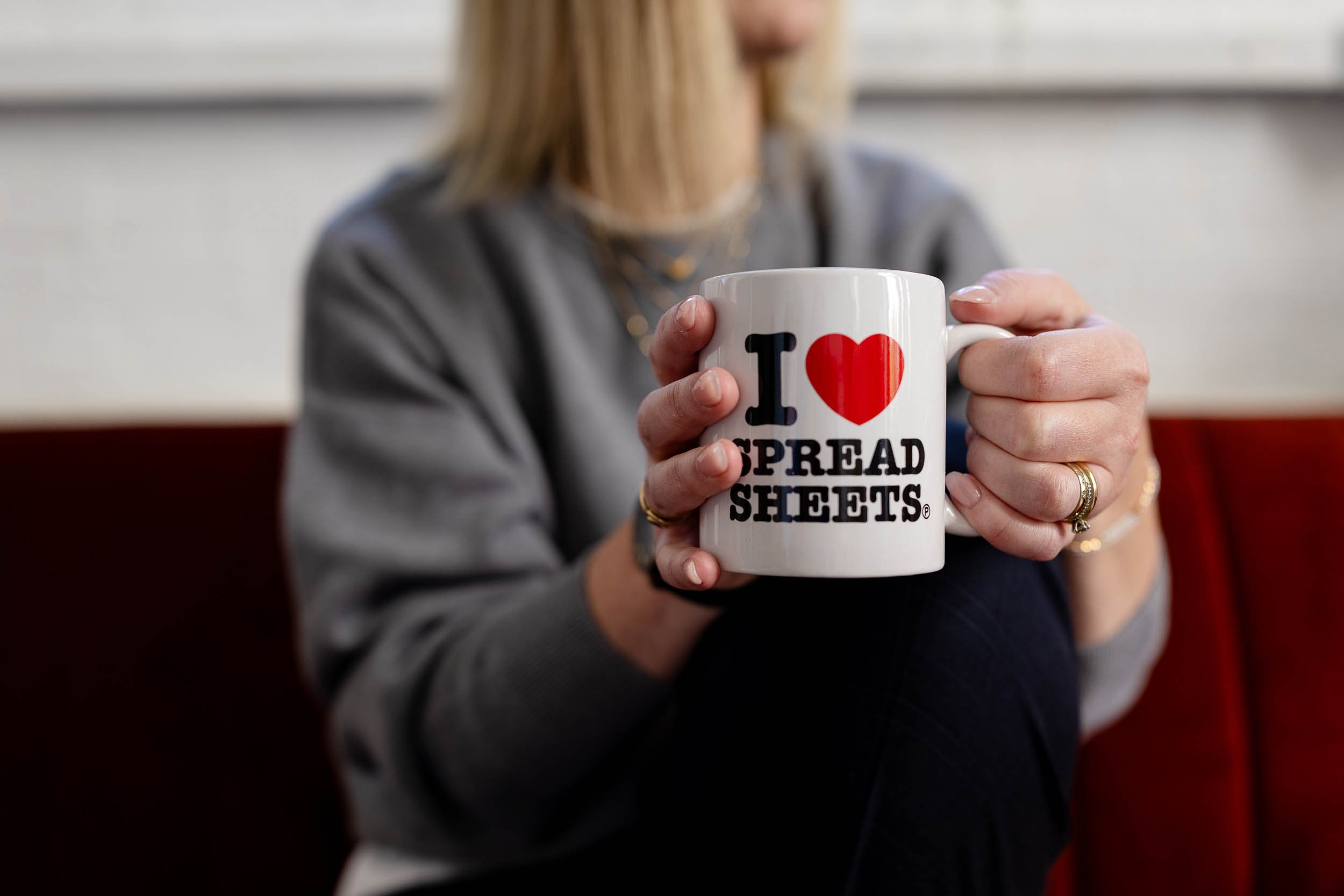 Retail consultant holding mug that says I Love Spreadsheets