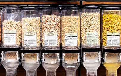 Bulk snack dispensers filled with different types of nuts and dried fruits.
