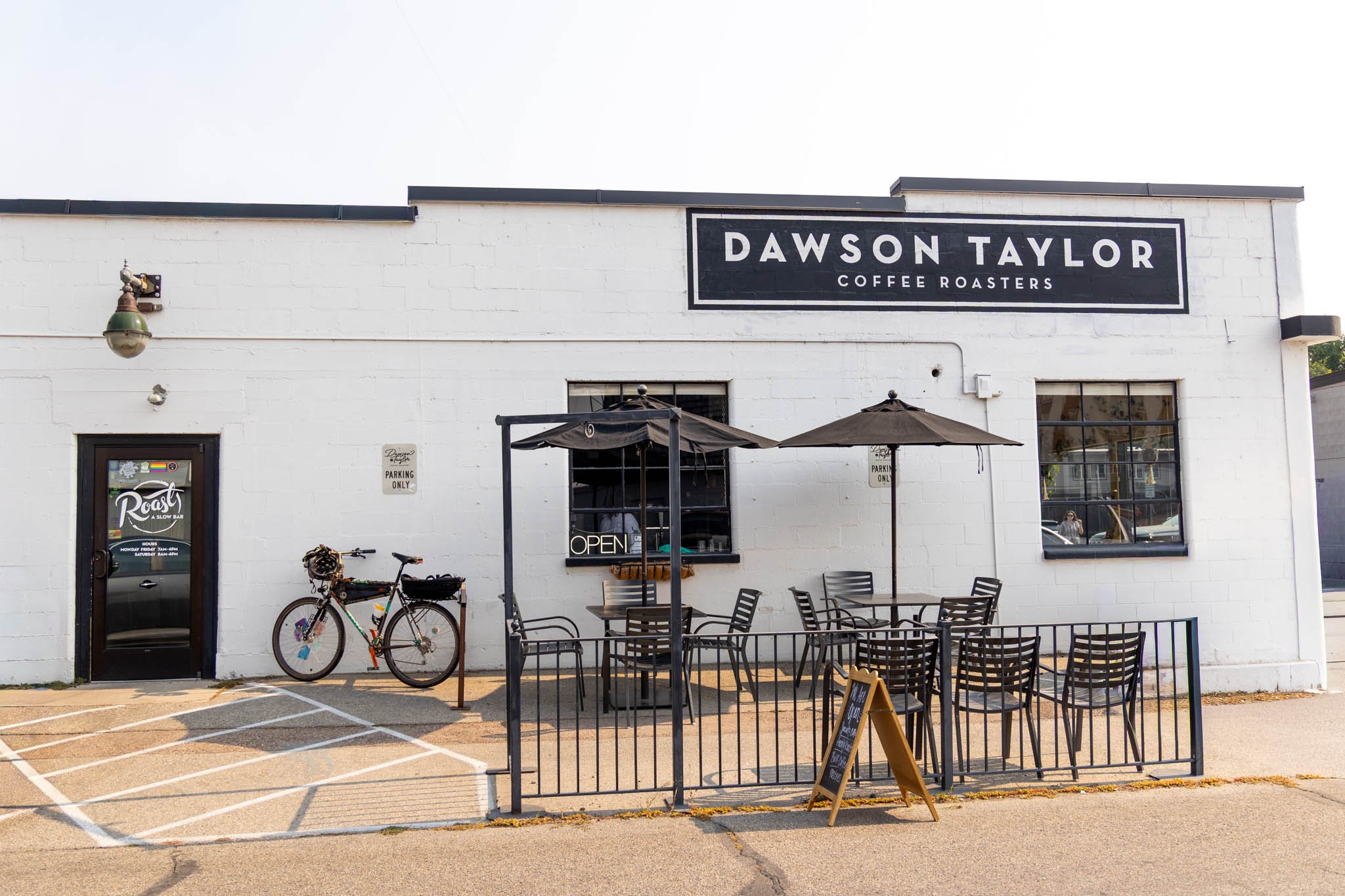 Exterior view of Dawson Taylor Coffee Roasters with outdoor seating, bicycles, and signage.