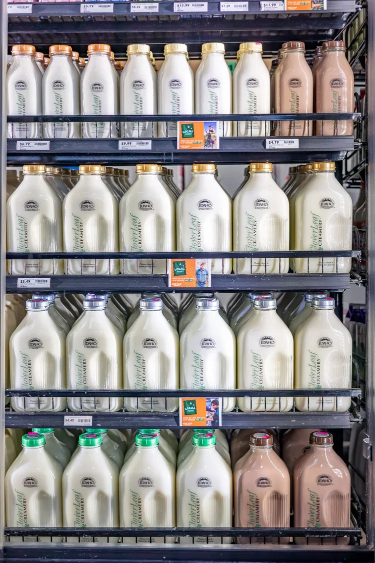 Shelves of bottles of cream and chocolate flavored drinks at a grocery store.