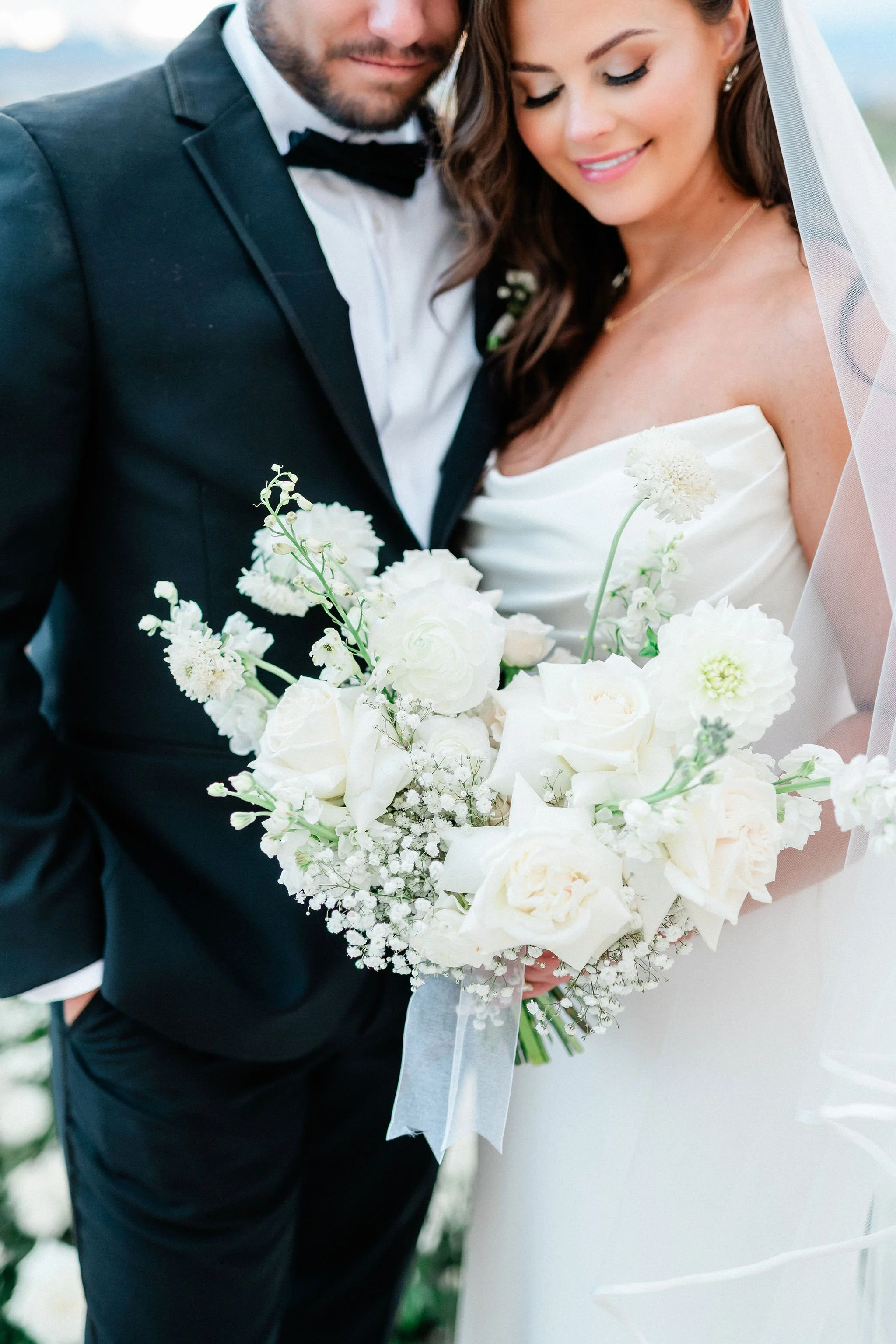 Close portrait of bride with white rose bouquet and soft glam makeup at Canyon Gate Country Club Las Vegas, hair and makeup by Marai A for Amelia C & Co, photography by Kristen Marie Weddings