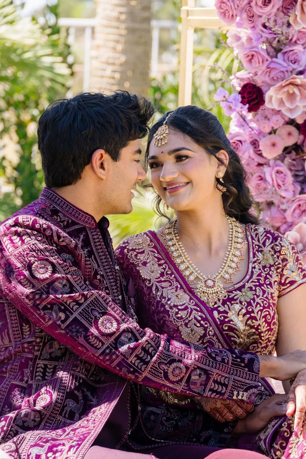  Indian bride and groom in matching purple embroidered wedding attire at Las Vegas engagement celebration, hair by Karen K and makeup by Natalia W for Amelia C & Co, photography by Elizabeth Burgi