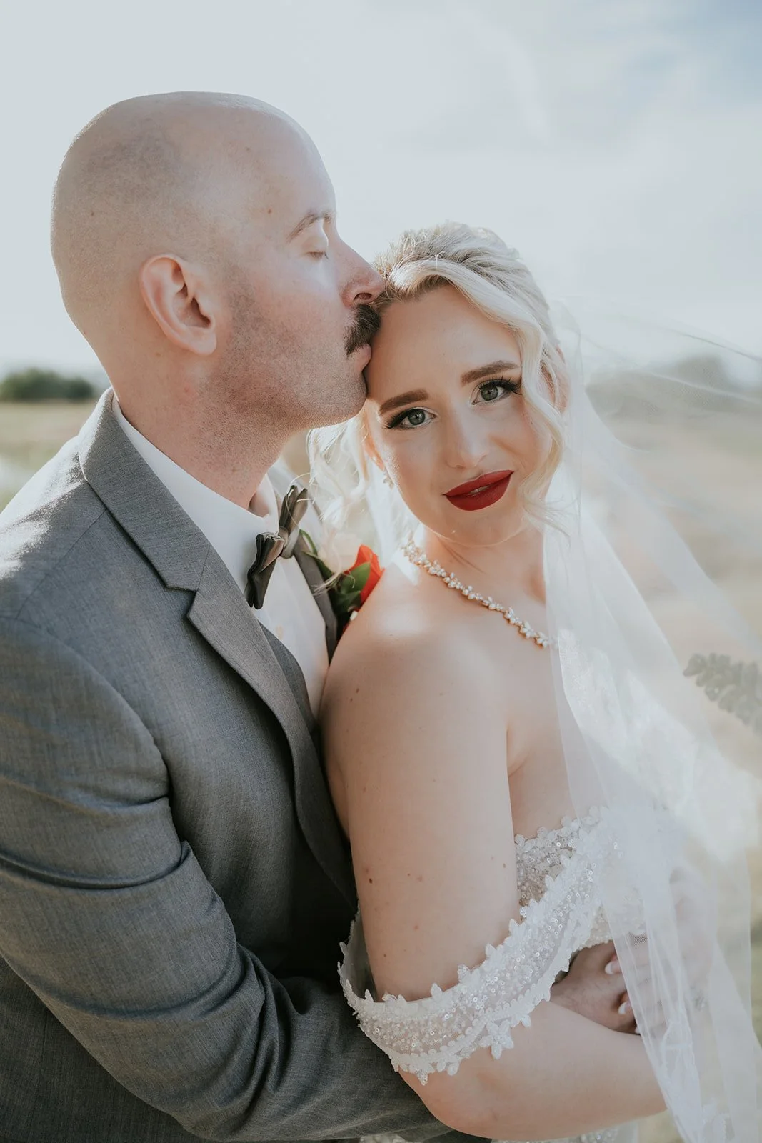 Groom Ian kissing bride Naomie's temple during couple portraits at Wedgewood Weddings Stallion Mountain wedding, hair by Courtney and makeup by Natalia for Amelia C & Co, photography by Stephen Salazar