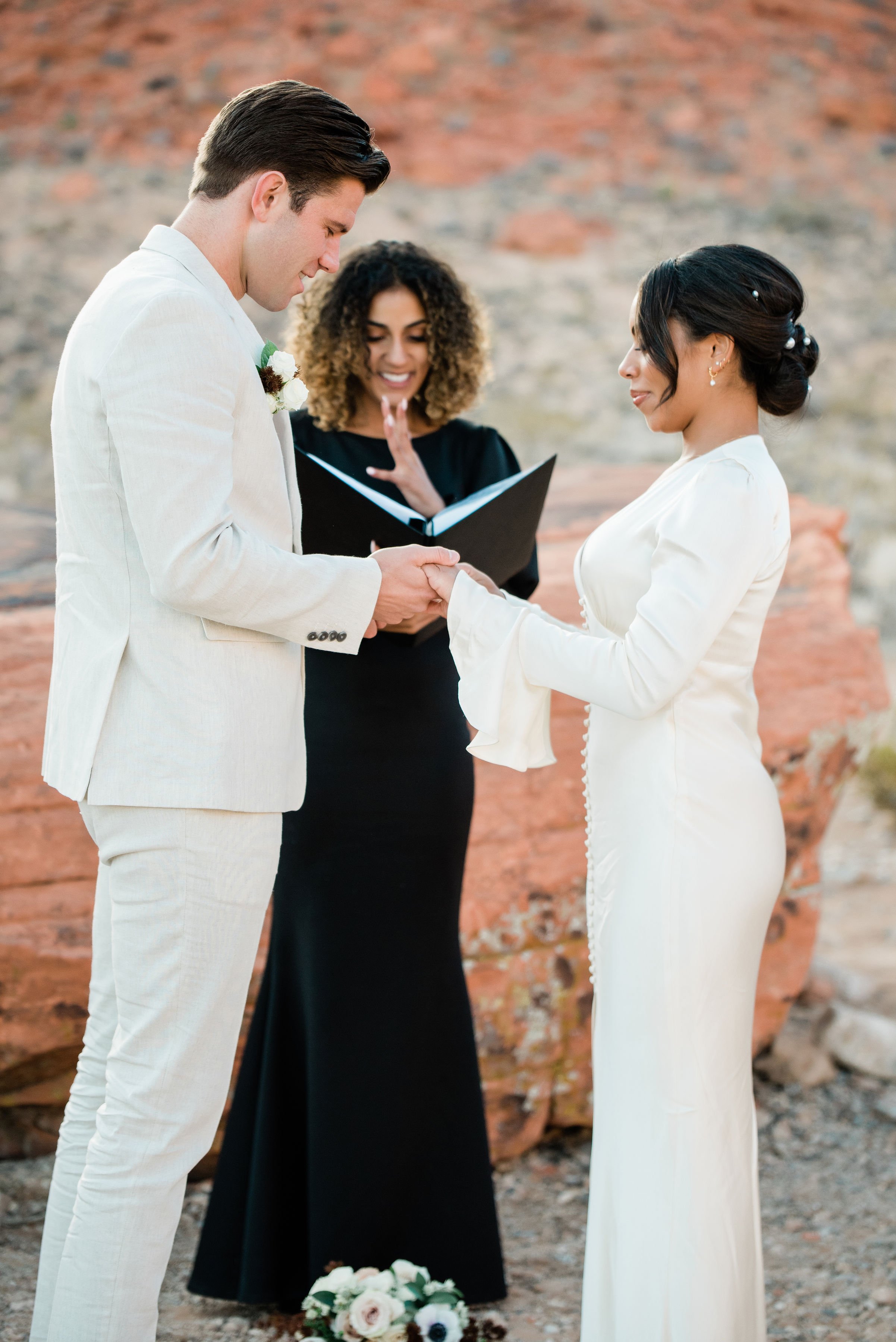 Martinique and James exchanging rings during elopement ceremony at Red Rock Canyon, hair and makeup by Luci for Amelia C & Co, photography by Cactus Collective Weddings
