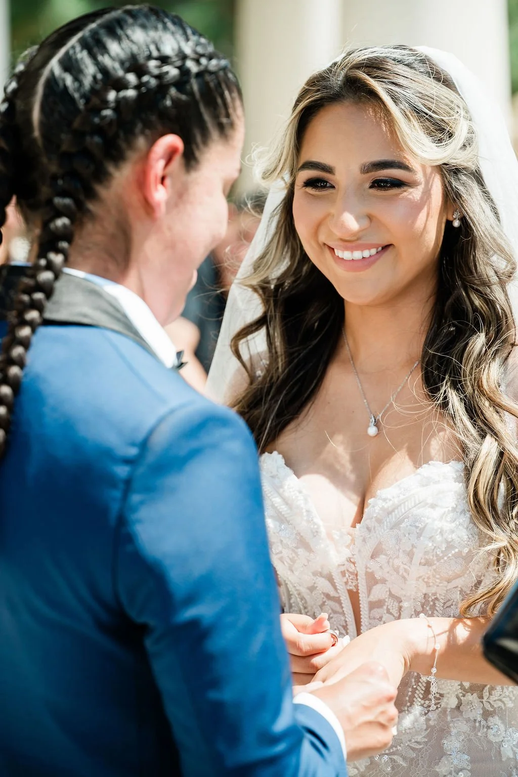 Joselynn and Azucena couple portrait at Las Vegas LGBTQ+ wedding, bride in lace gown and partner in suspenders and bow tie, hair and makeup by Hailee for Amelia C & Co, photography by Cactus Collective Weddings