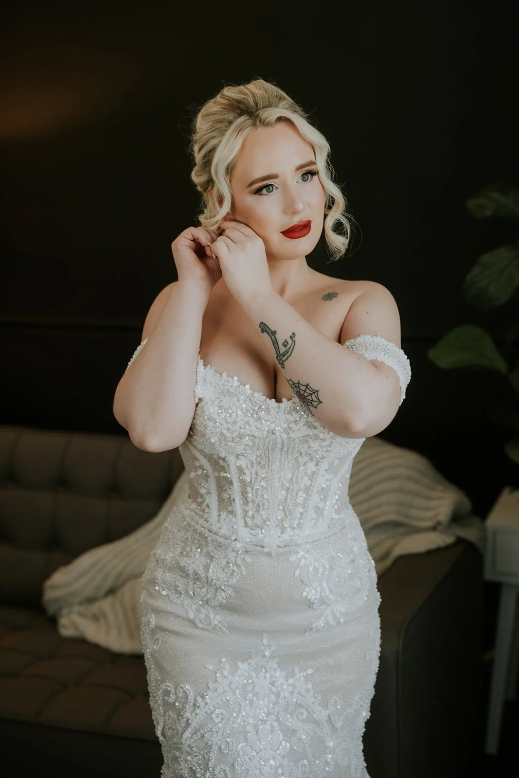 Bride Naomie adjusting earring in off-shoulder beaded gown at Wedgewood Weddings Stallion Mountain wedding, hair by Courtney and makeup by Natalia for Amelia C & Co, photography by Stephen Salazar
