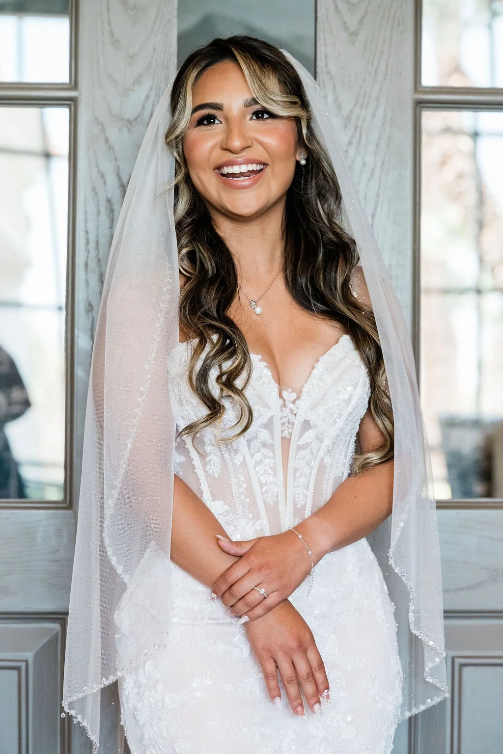 Close-up bridal portrait of Joselynn with veil and highlighted curls at Las Vegas LGBTQ+ wedding, hair and makeup by Hailee for Amelia C & Co, photography by Cactus Collective Weddings