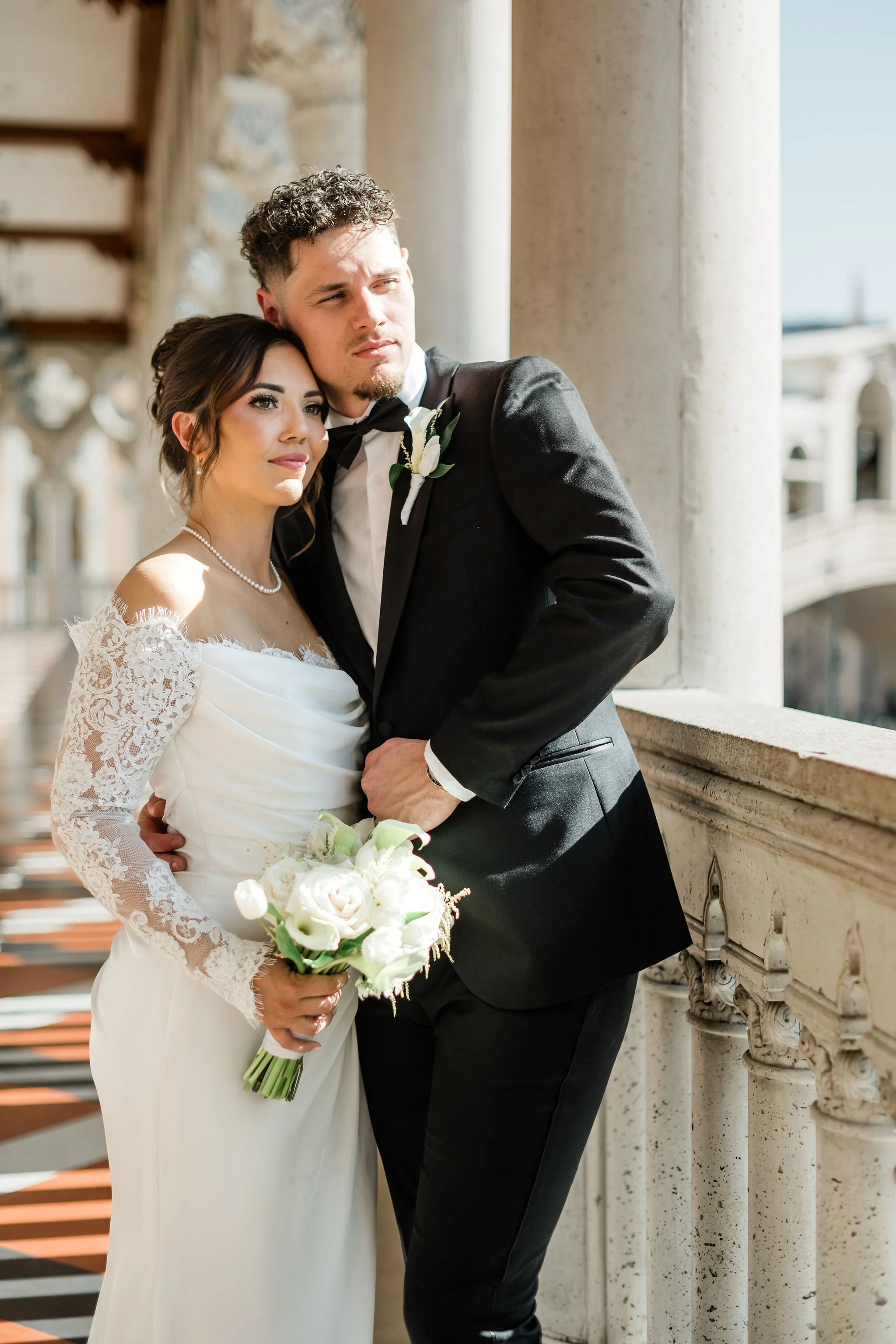  Bride Jessica and groom Lukas posing at The Venetian Las Vegas colonnade balcony, hair by Katie and makeup by Aimee for Amelia C & Co, photography by Liz Le