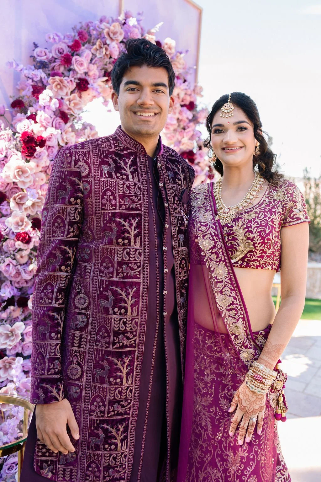  Indian bride and groom in coordinating purple embroidered traditional attire at Las Vegas engagement celebration, hair by Karen K and makeup by Natalia W for Amelia C & Co, photography by Elizabeth Burgi