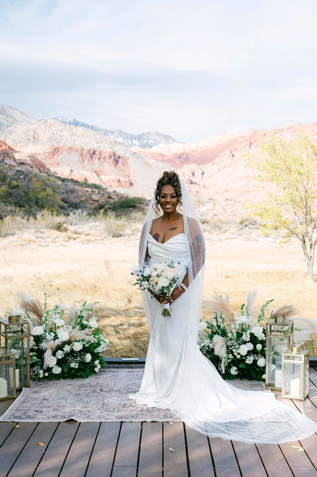 Full-length bridal portrait of Aretha in strapless gown with cathedral train and pearl veil on ceremony deck at Red Spring Boardwalk Las Vegas elopement, hair by Courtney and makeup by Natalia for Amelia C & Co, photography by Desert Wildflower