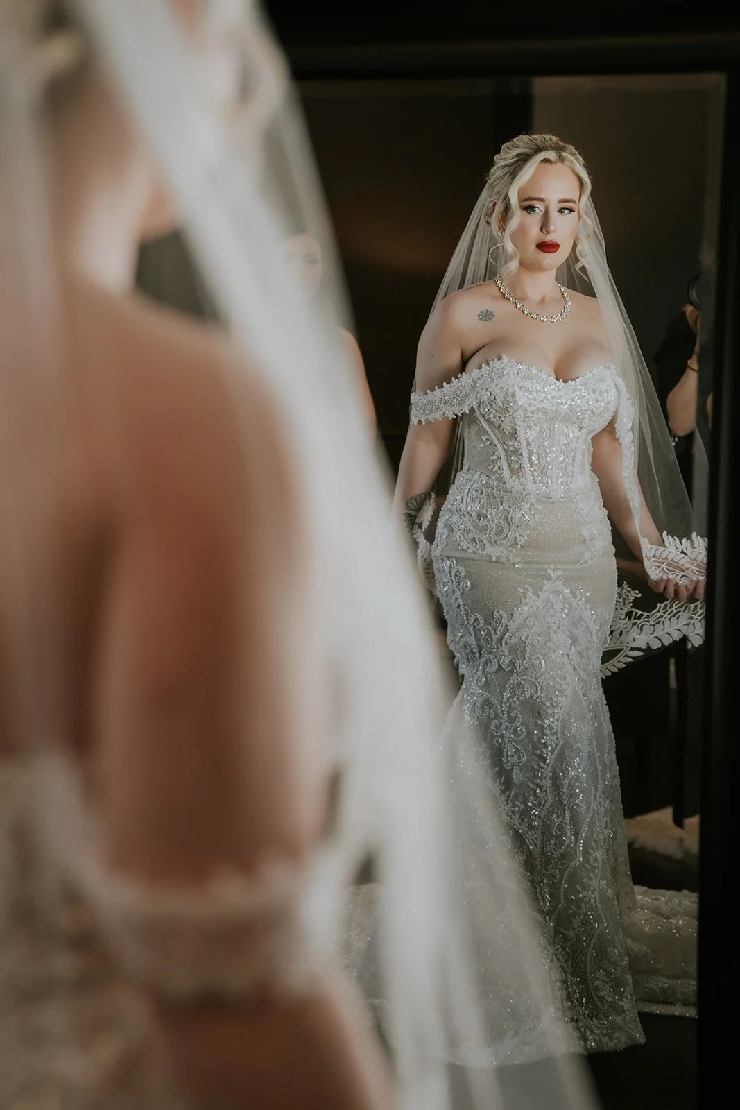 Bride Naomie reflected in mirror wearing veil and beaded off-shoulder gown at Wedgewood Weddings Stallion Mountain wedding, hair by Courtney and makeup by Natalia for Amelia C & Co, photography by Stephen Salazar