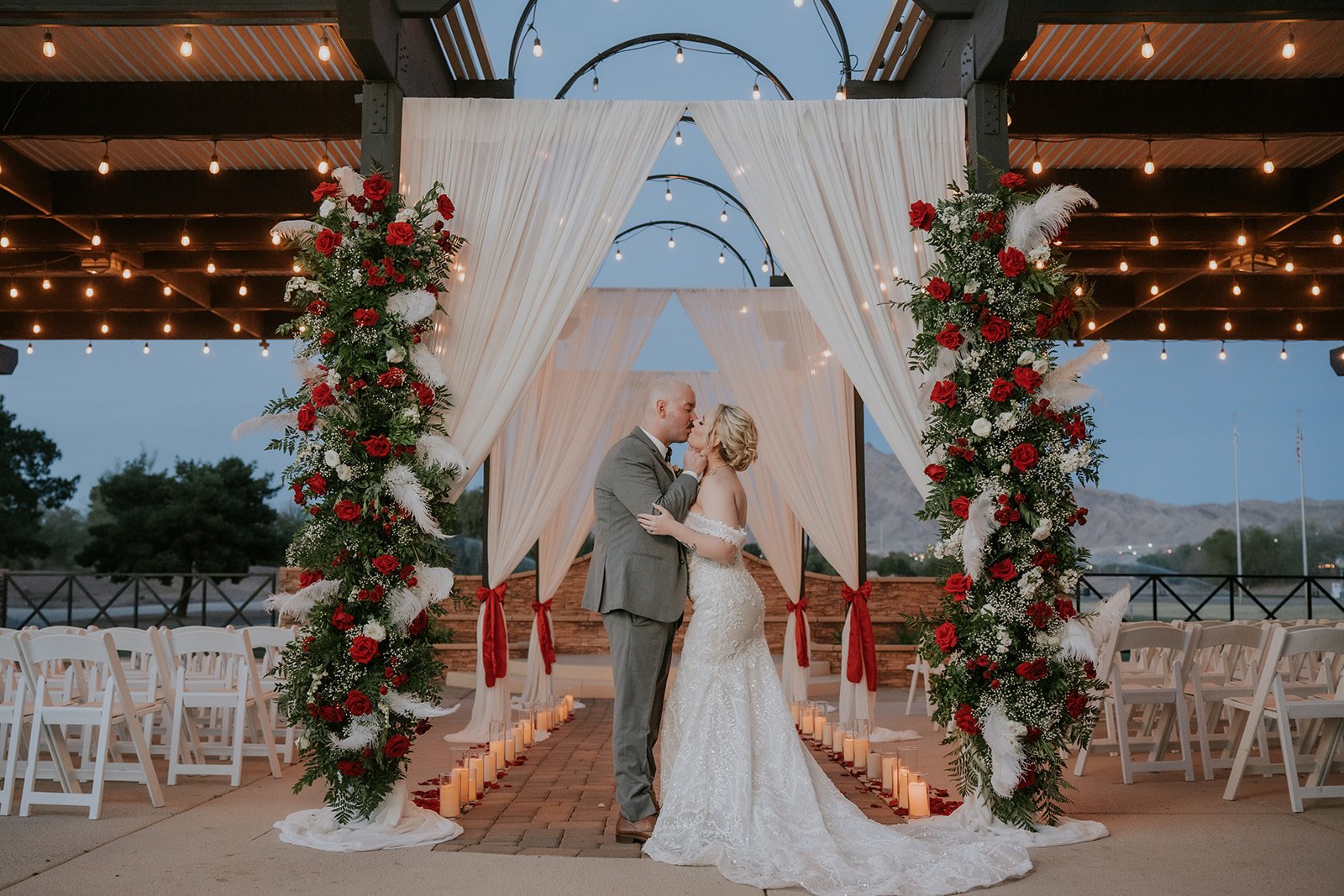 Bride Naomie and groom Ian embracing in tall grass at golden hour at Wedgewood Weddings Stallion Mountain wedding, hair by Courtney and makeup by Natalia for Amelia C & Co, photography by Stephen Salazar