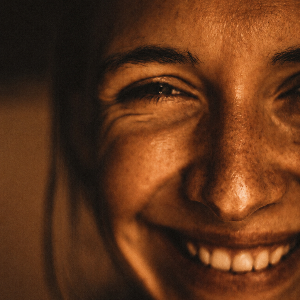 Close-up d'une personne souriante, montrant une partie du visage avec un sourire large et des dents visibles.
