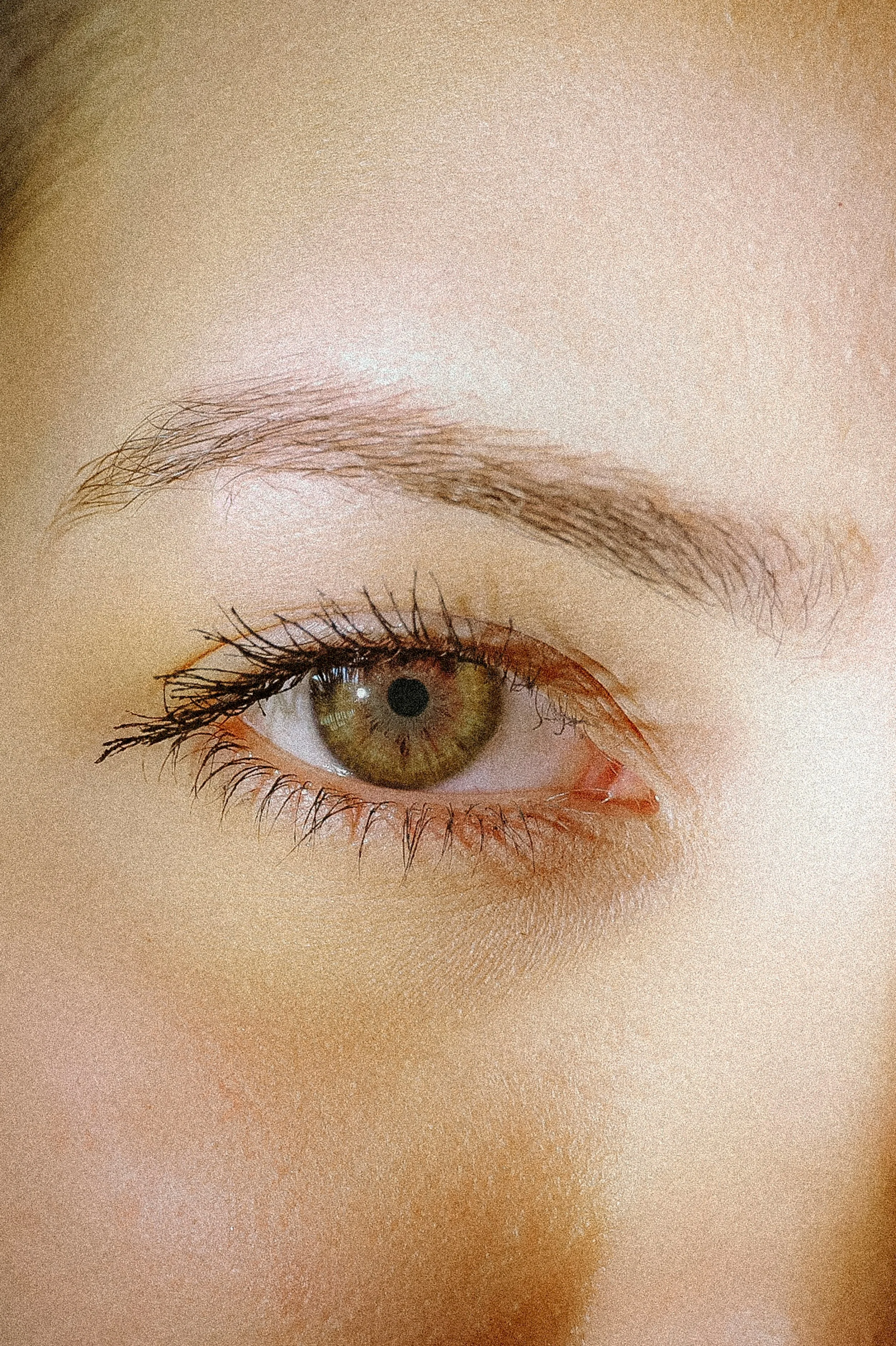 Zoom sur un œil humain, révélant la couleur verte, le sourcil épilé et les cils longs et définis. Clairvoyance, discernement.