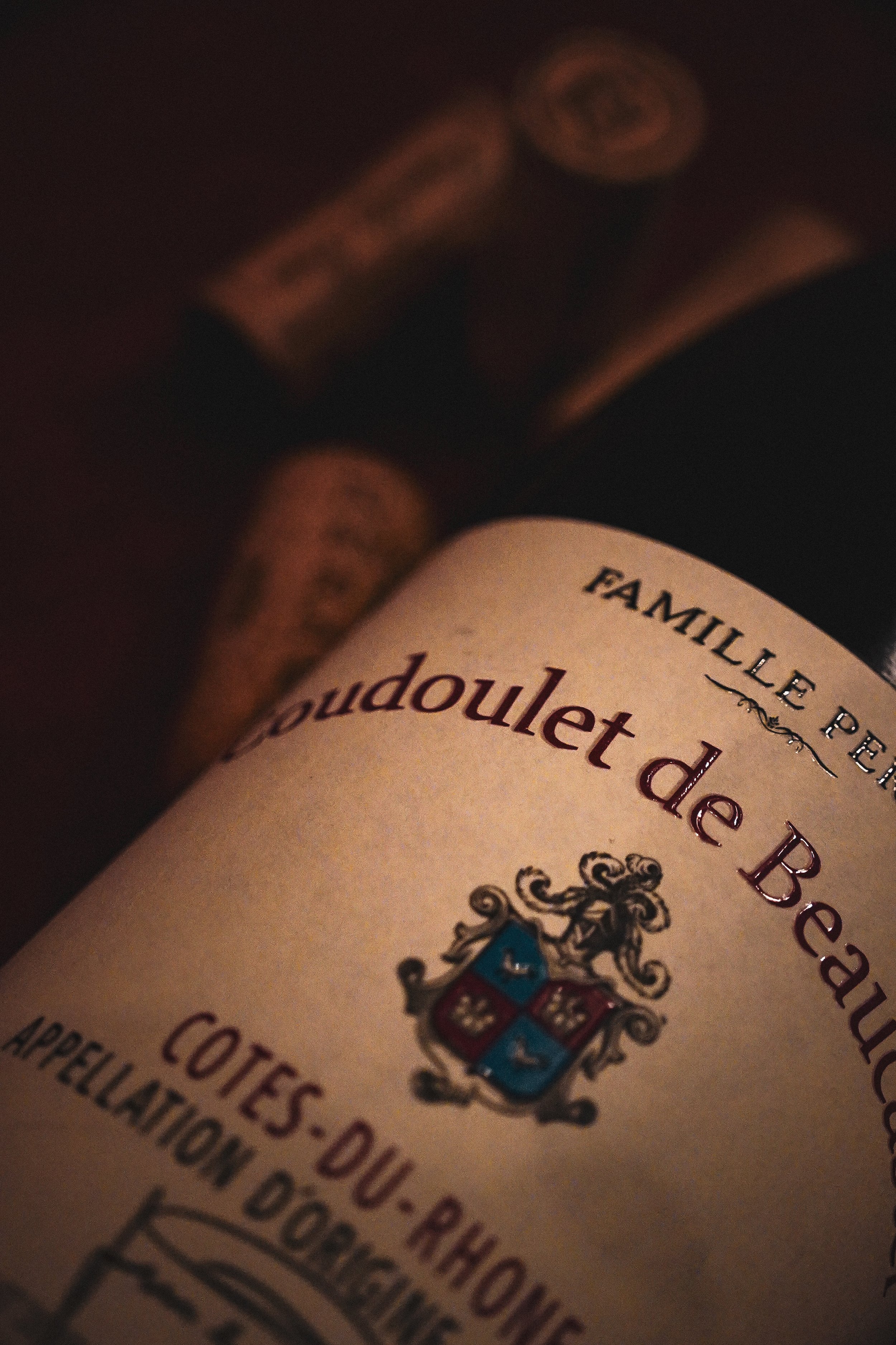 Étiquette de bouteille de vin avec un blason, le texte 'Famille P...', et une illustration d'une coquille de pétoncle.