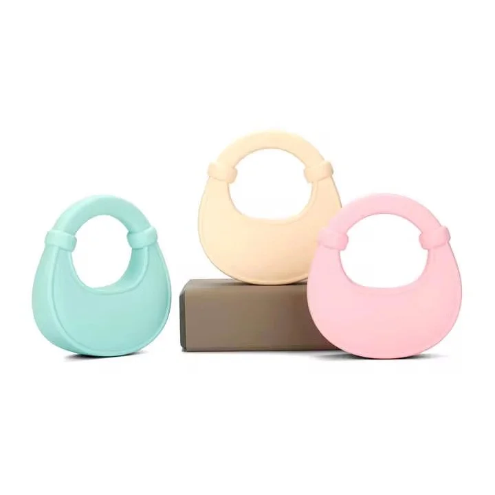 Three pastel-colored handbags in mint green, cream, and pink displayed on a black pedestal against a white background.