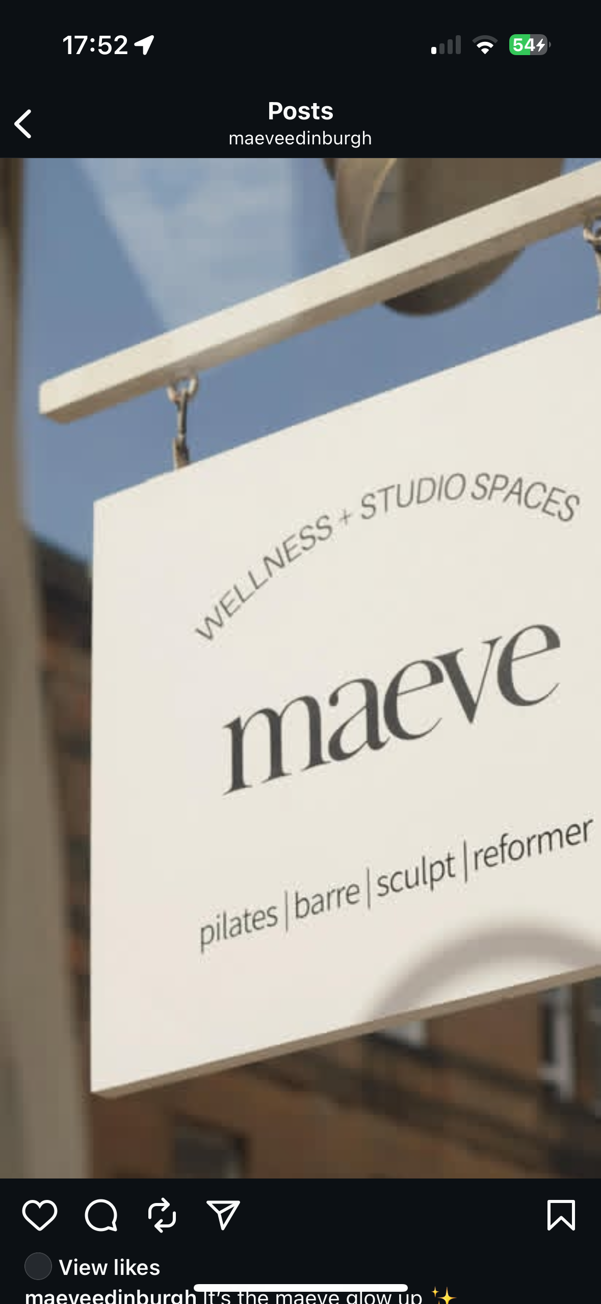 A sign hanging outdoors for 'Maeve,' a wellness and studio space offering pilates, barre, sculpt, and reformer classes, against a blue sky background.