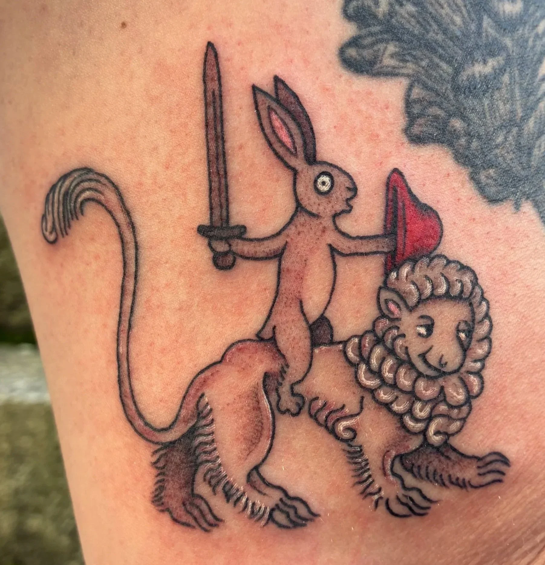 Fineline tattoo of a sword-wielding rabbit riding a lion, medieval marginalia illustration style