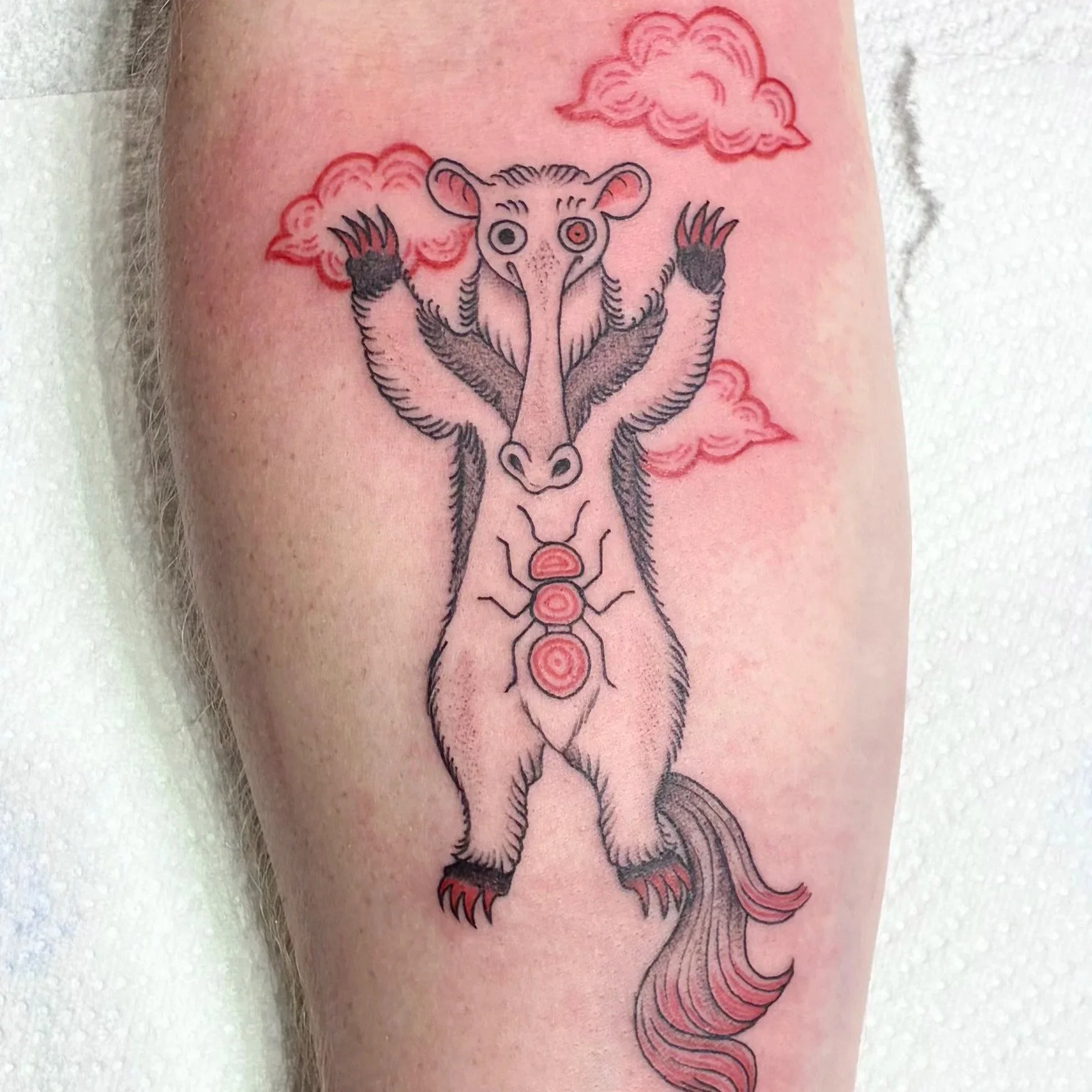 Fineline tattoo of an anteater with raised arms among clouds, whimsical bestiary style