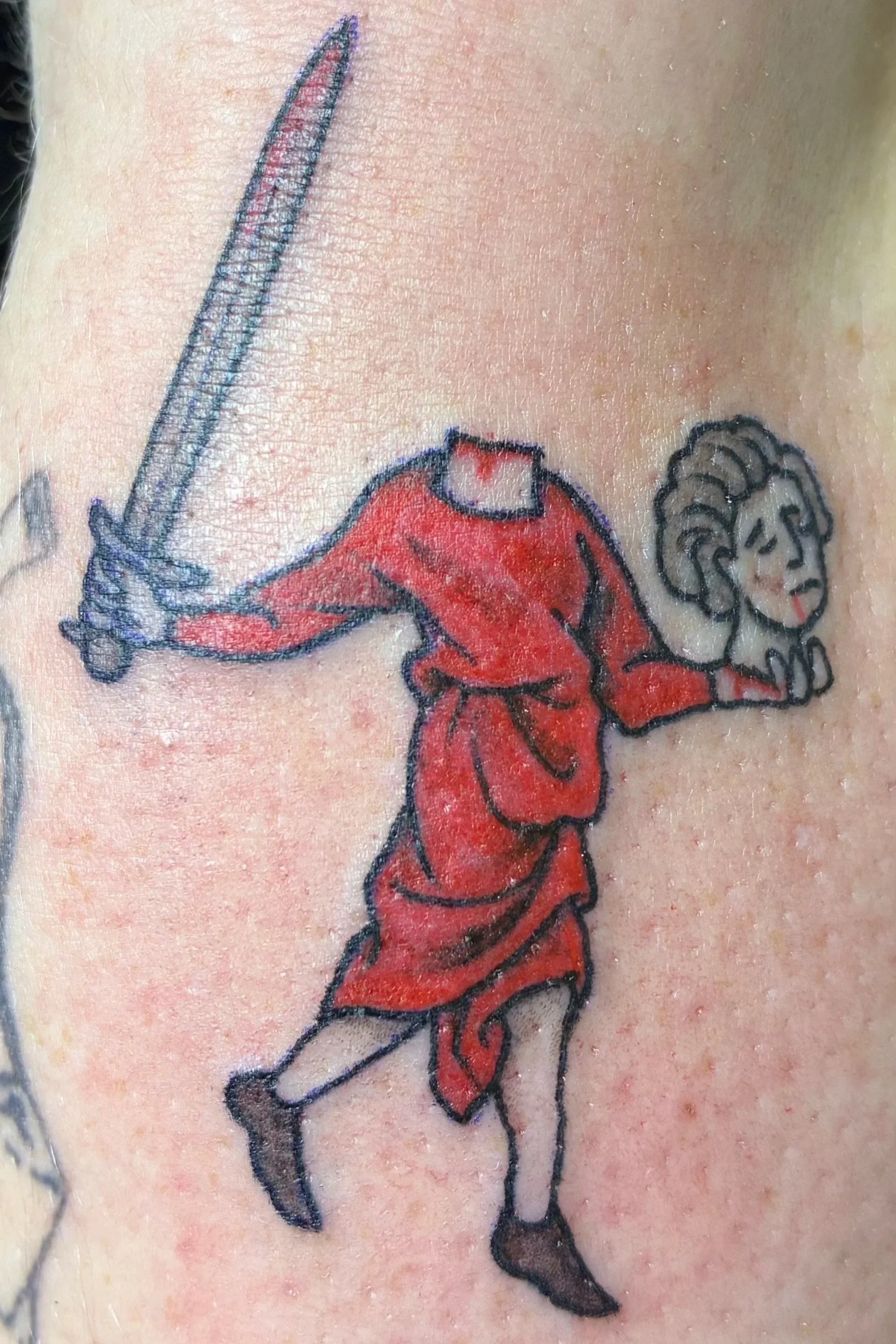 Color tattoo of a headless figure in red robes holding a sword and severed head, medieval marginalia illustration